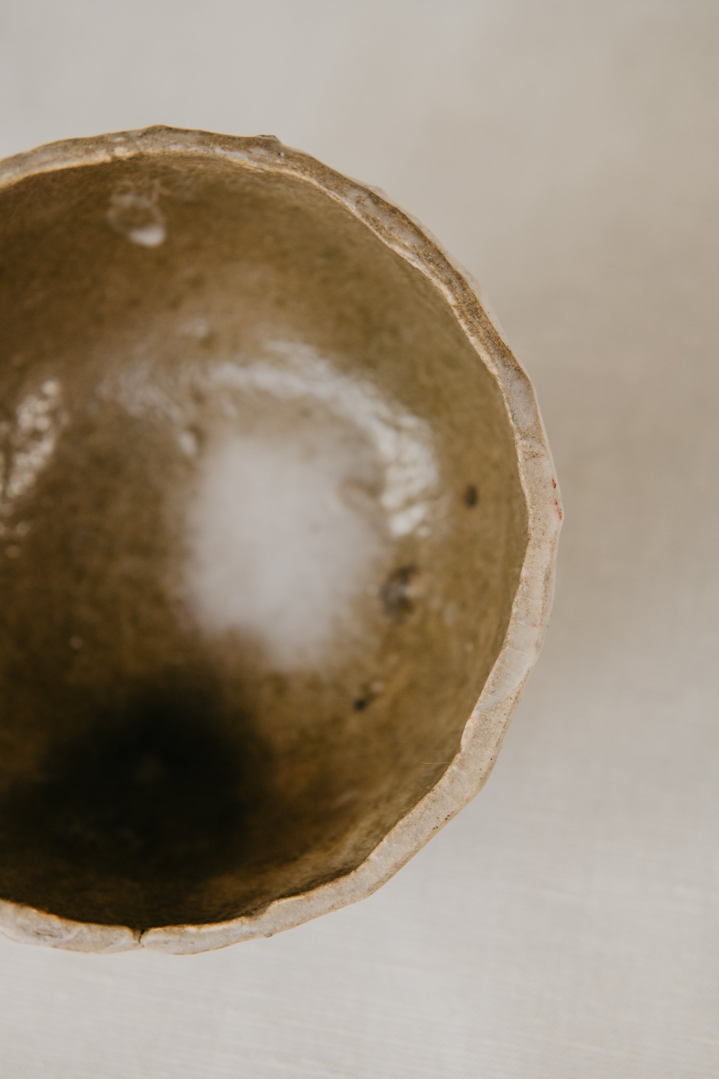 Close-up of a ceramic bowl with a textured surface on a neutral background