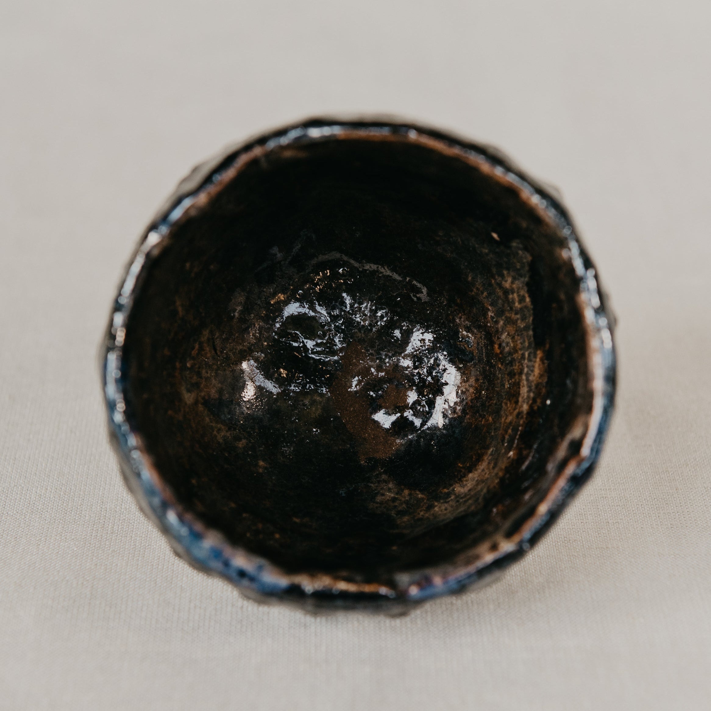 Close-up of a dark brown ceramic cup on a light gray background