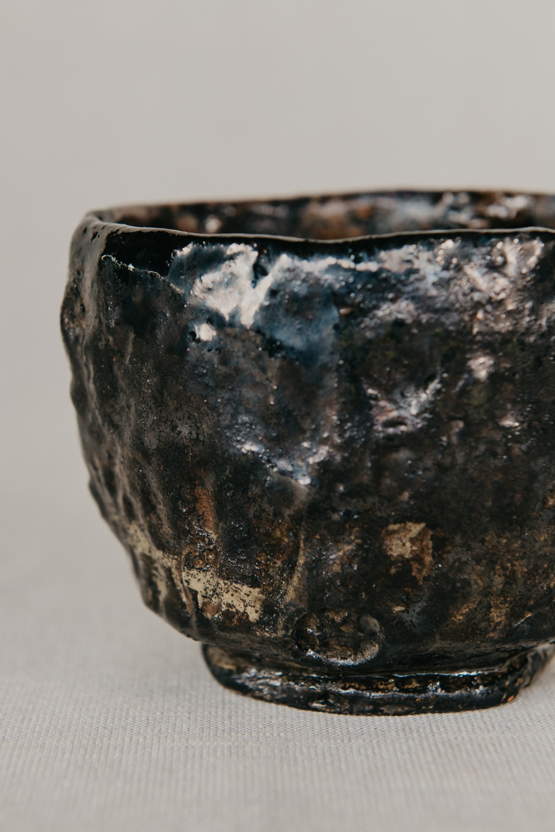 Black ceramic bowl with textured surface on a light gray background