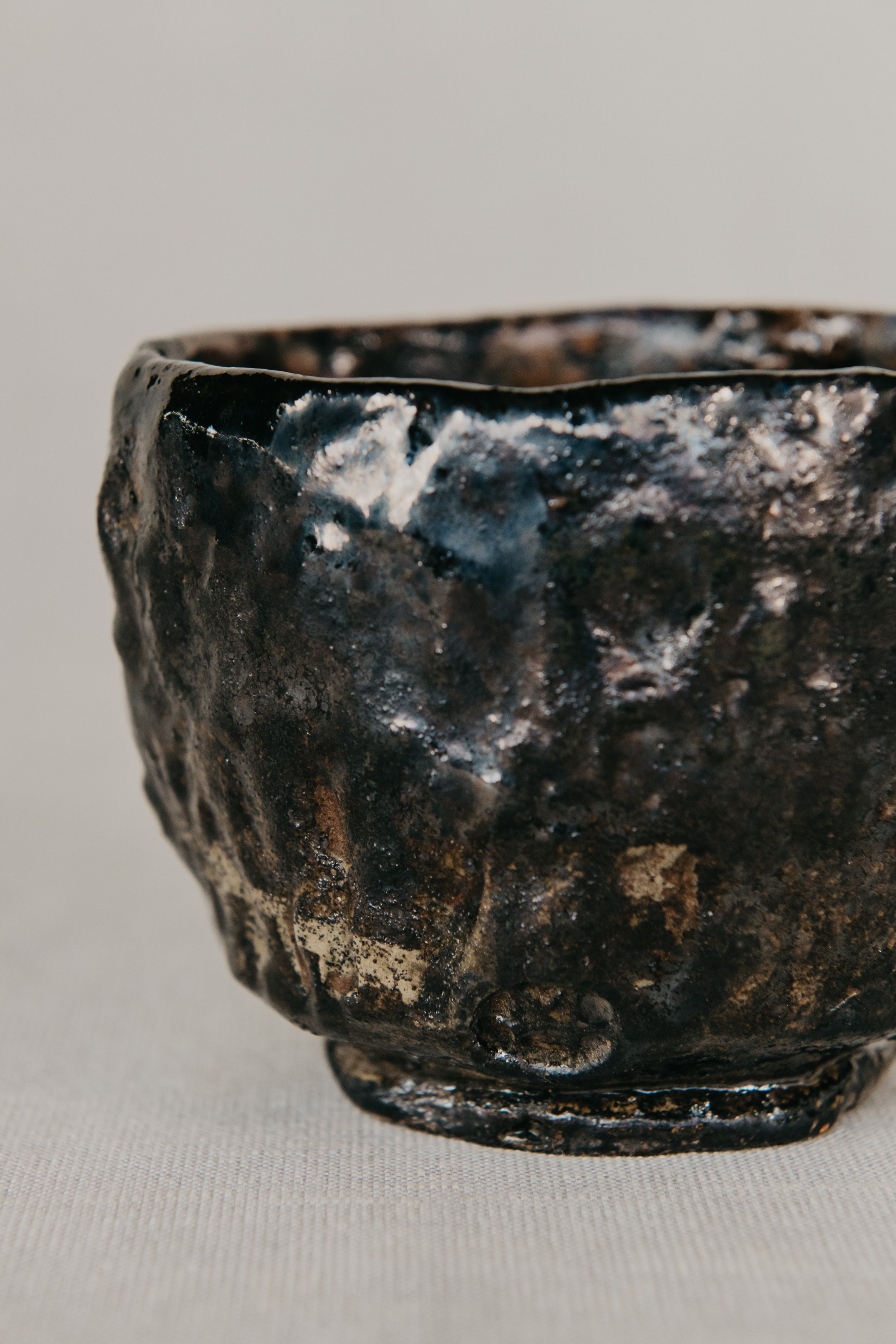Black ceramic bowl with textured surface on a light gray background