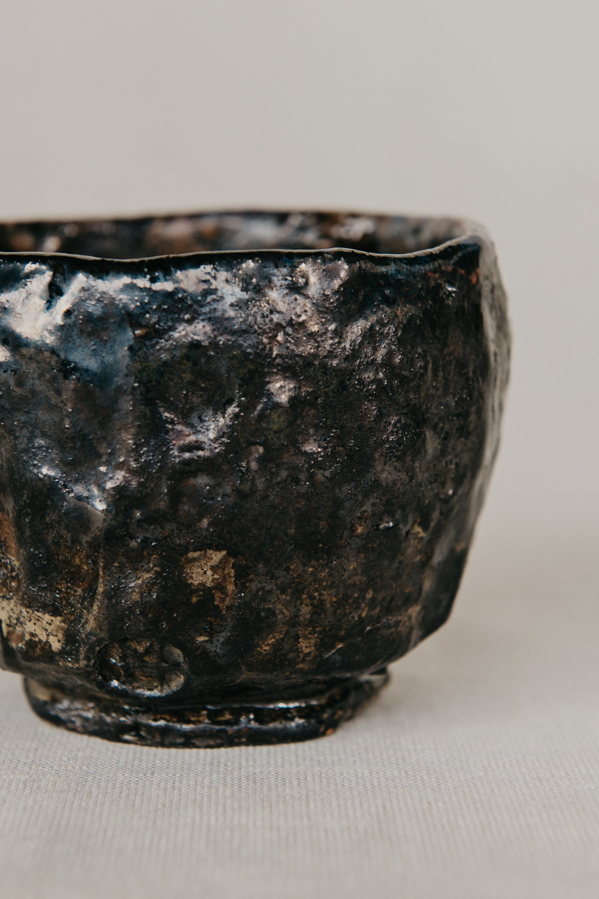 Black ceramic bowl with a textured surface on a light gray background
