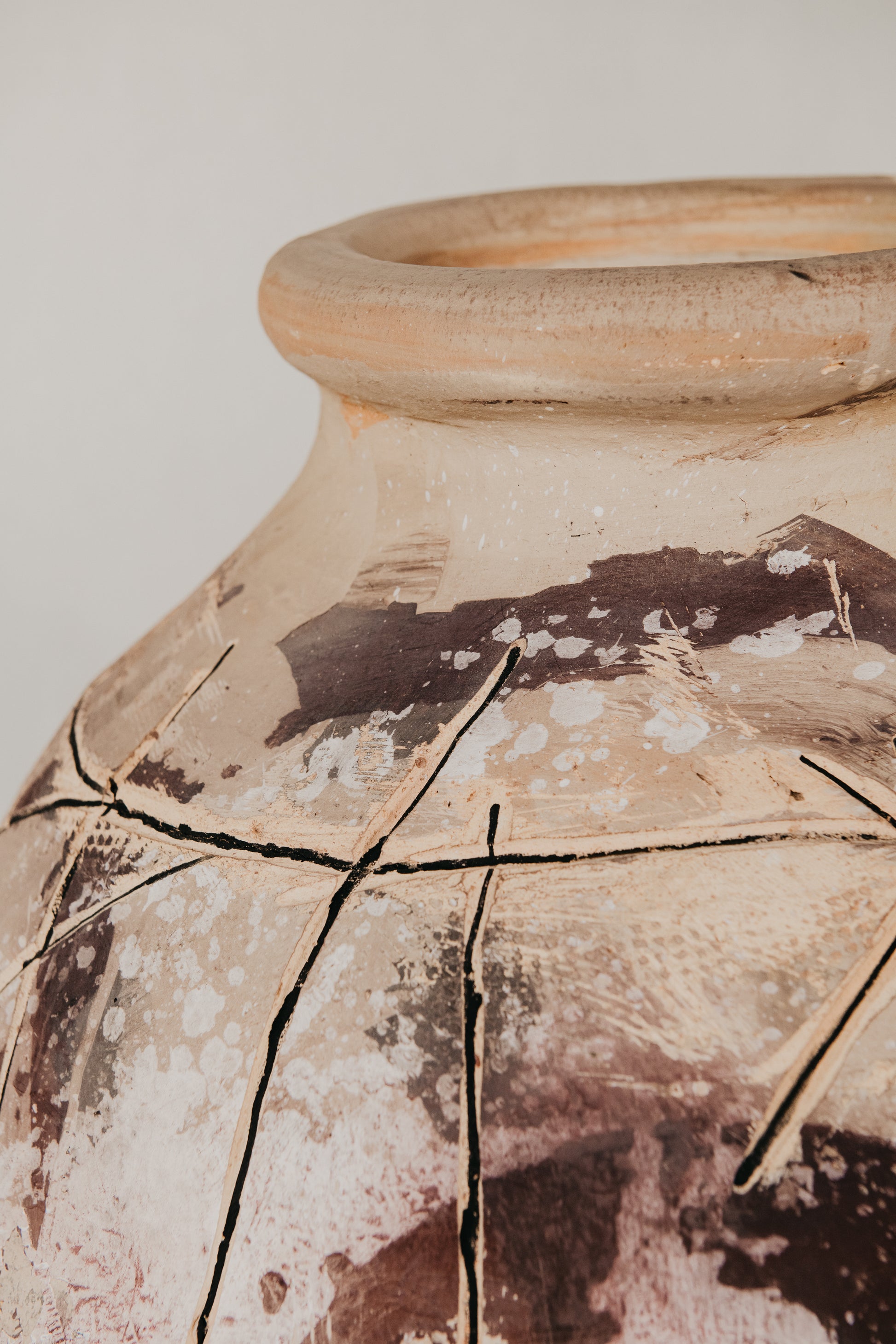 Close-up of a cracked ceramic vase with a plain background