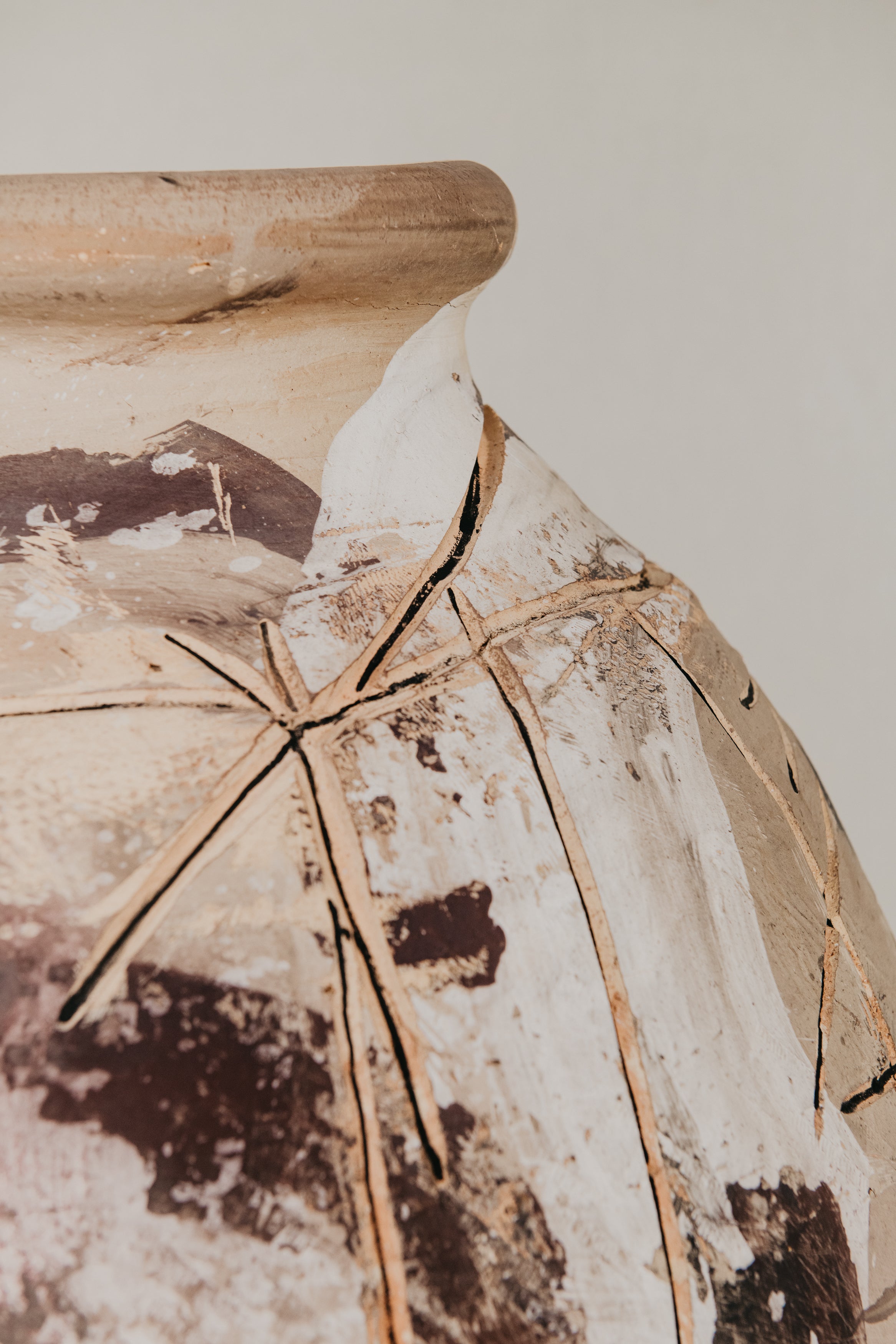 Close-up of a textured vase with a crack, on a plain background