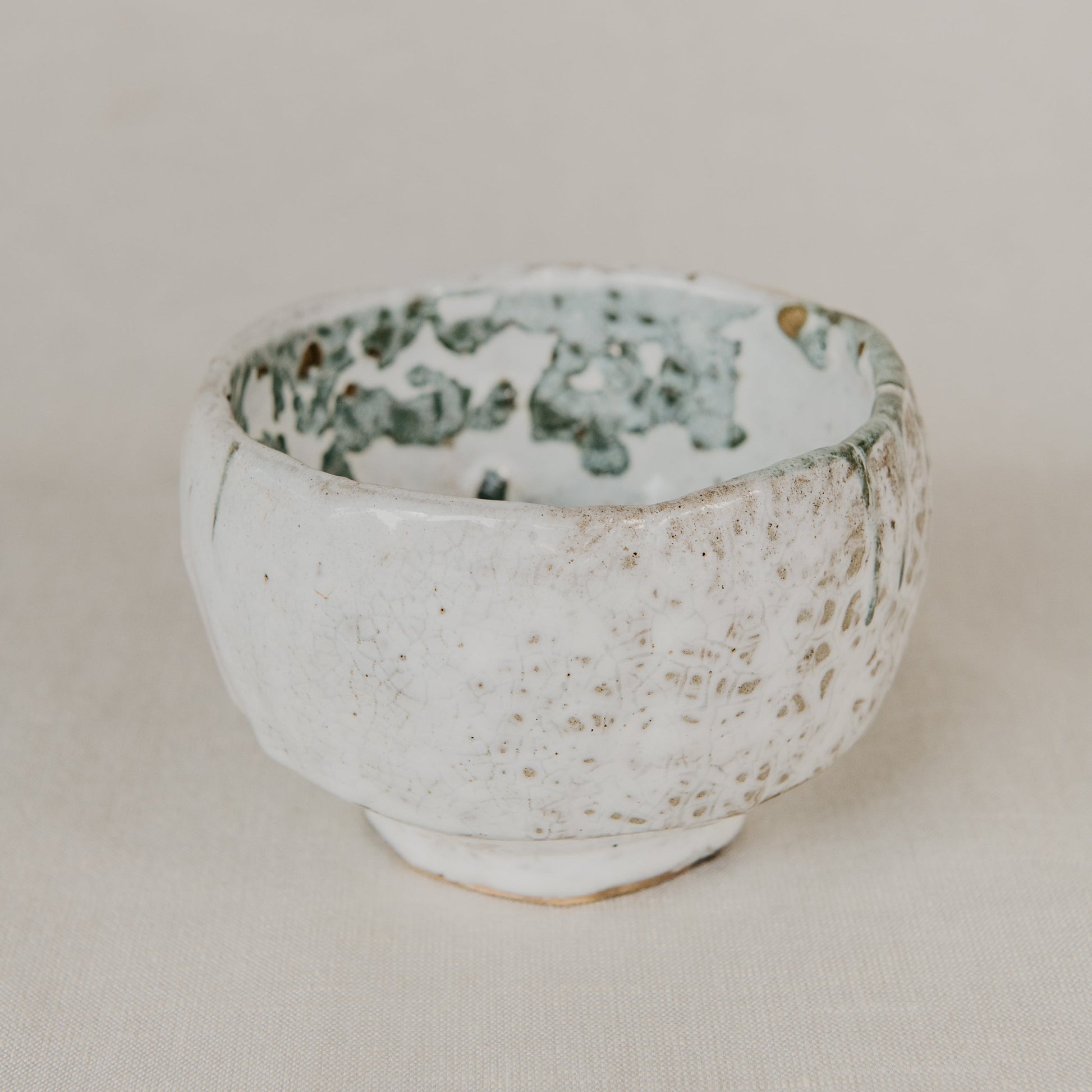 Ceramic bowl with speckled design on a beige background