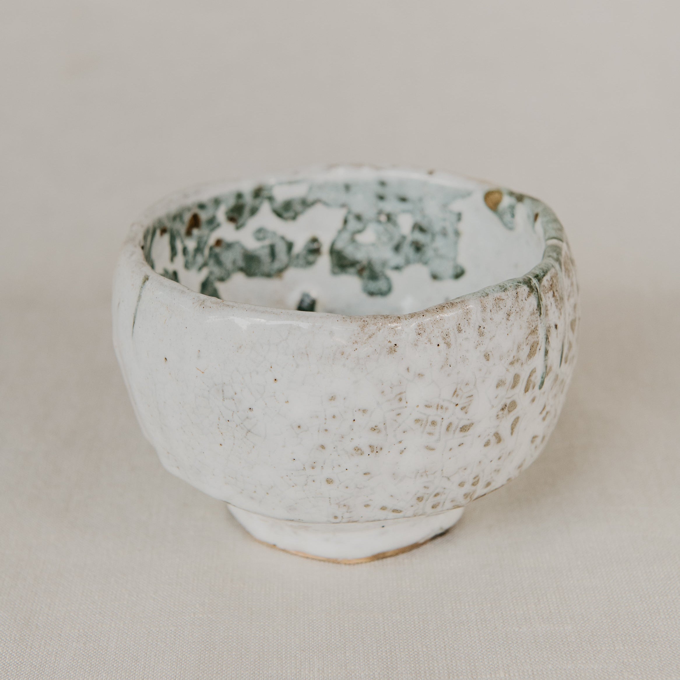 Ceramic bowl with speckled design on a beige background