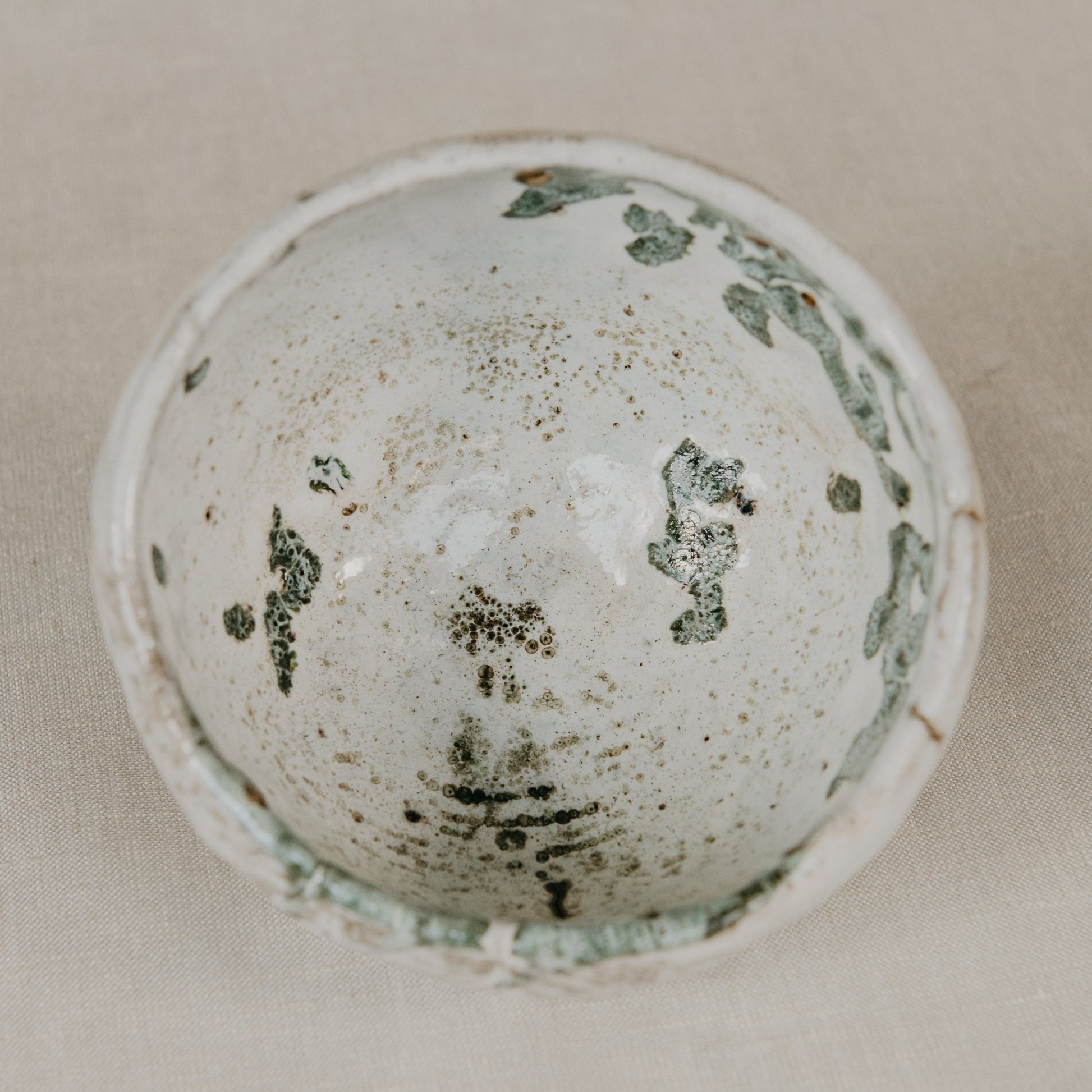 Vintage ceramic bowl with a textured surface on a beige background