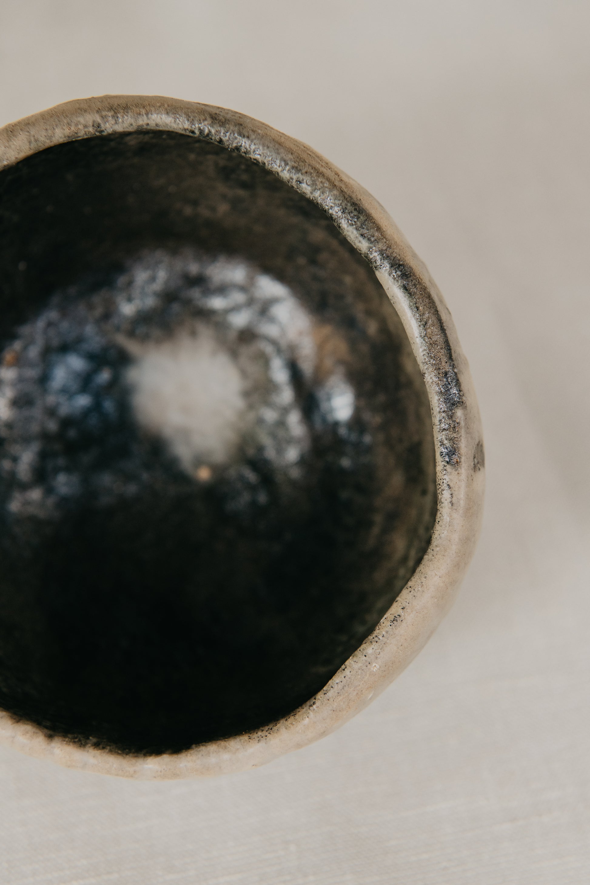 Close-up of a ceramic bowl with a textured interior on a neutral background