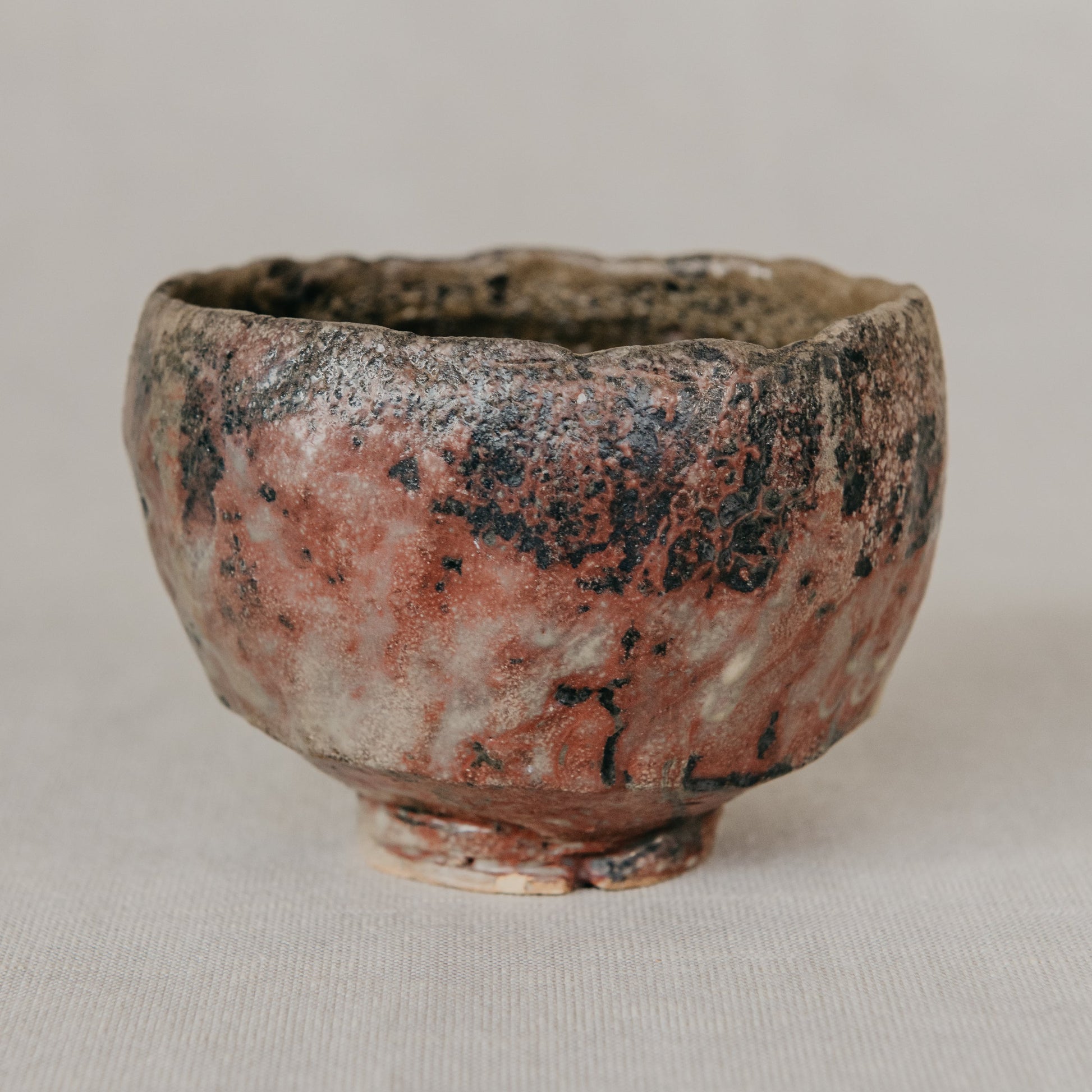Small ceramic cup with a textured surface on a plain background