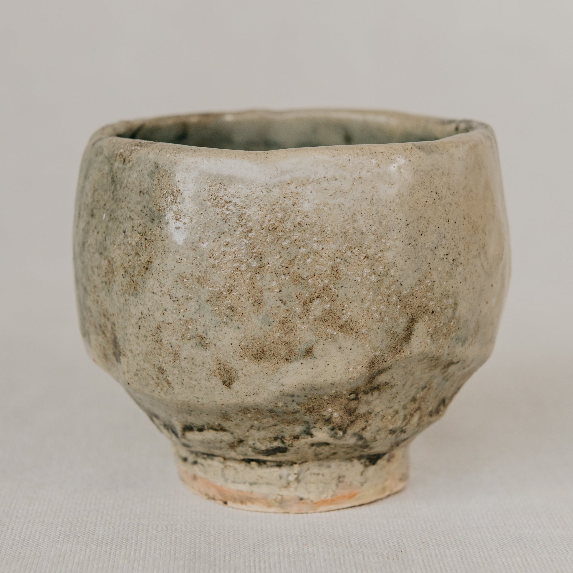 Ceramic cup with a textured surface on a plain background