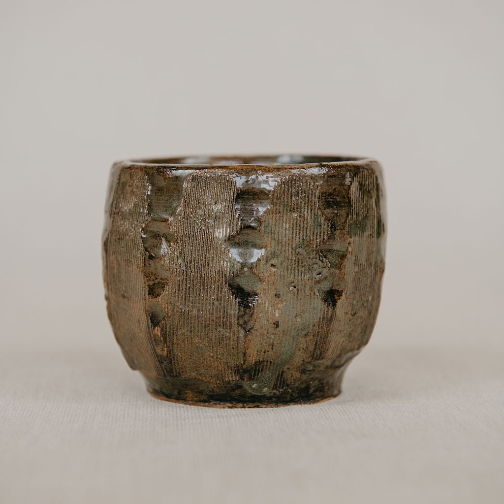 Textured ceramic cup on a plain background