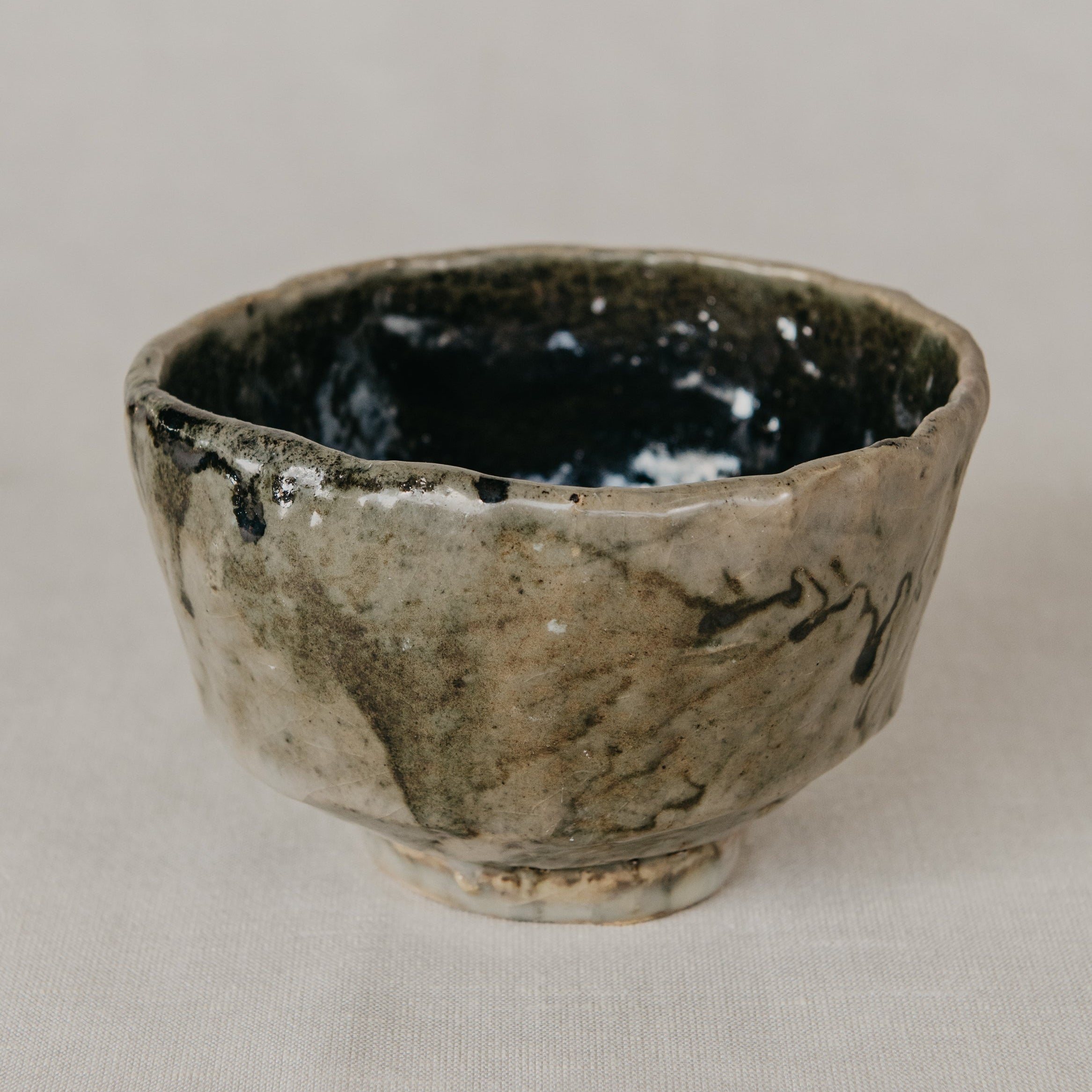 Ceramic cup with black interior on a beige background