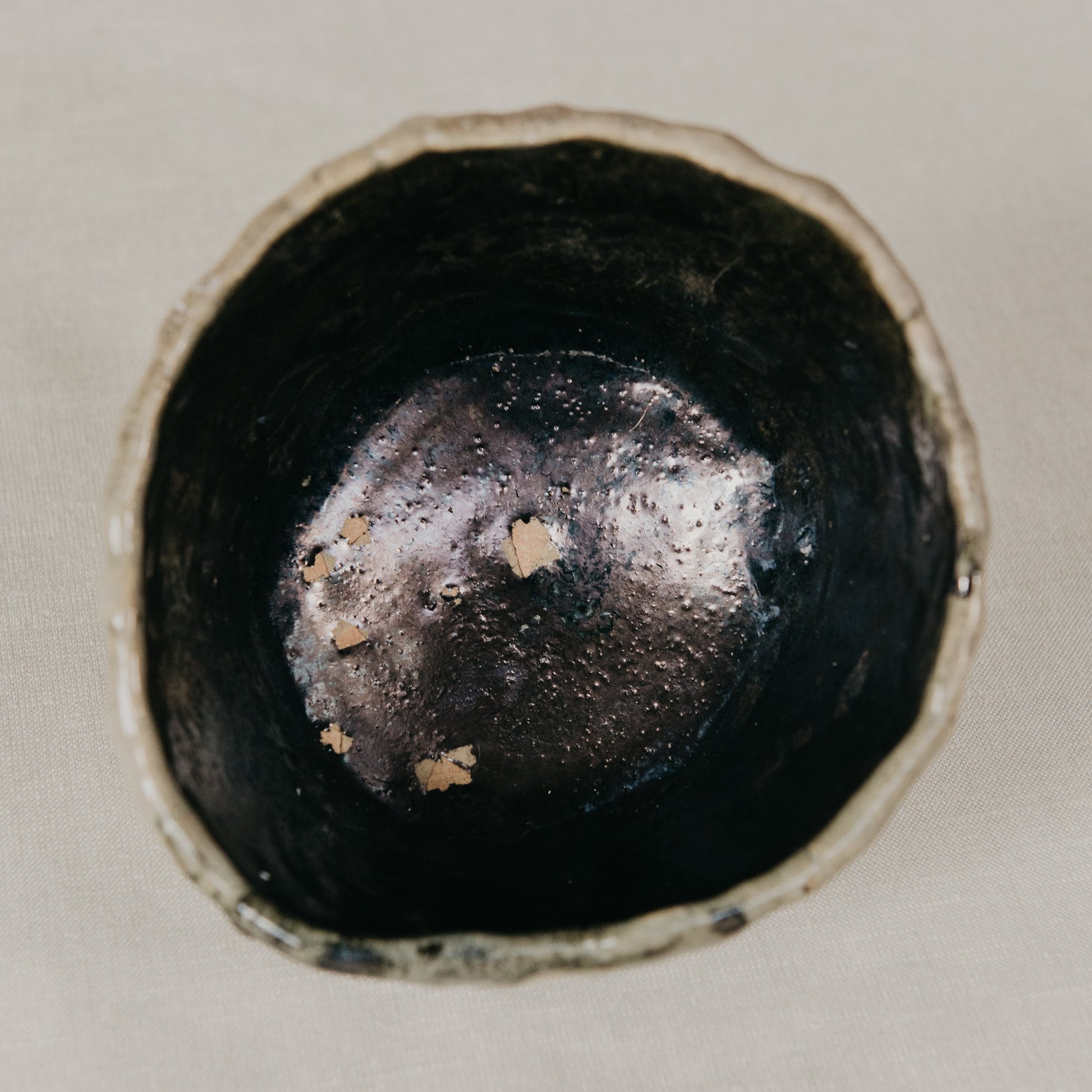 Close-up of a black ceramic bowl on a light beige background