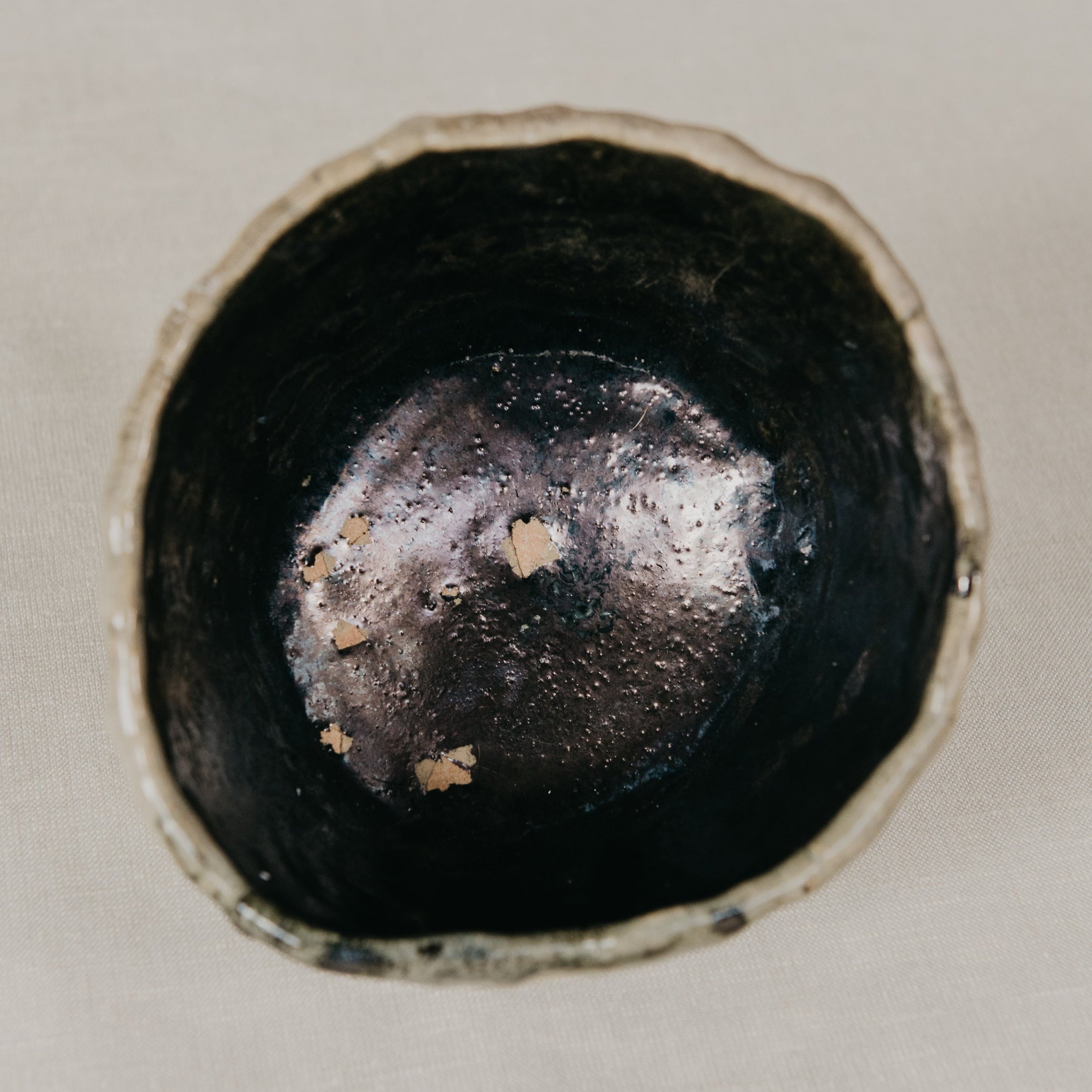 Close-up of a black ceramic bowl on a light beige background