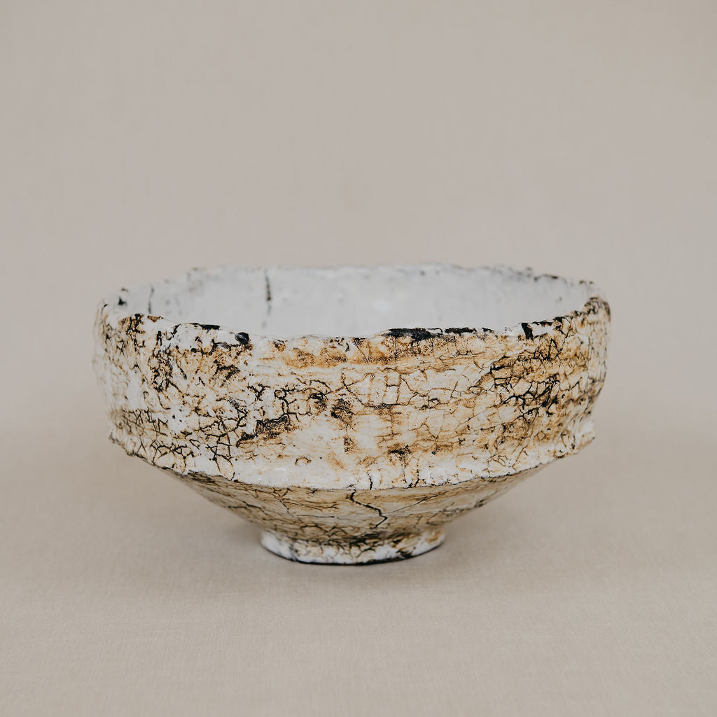 Ceramic bowl with textured surface on a beige background