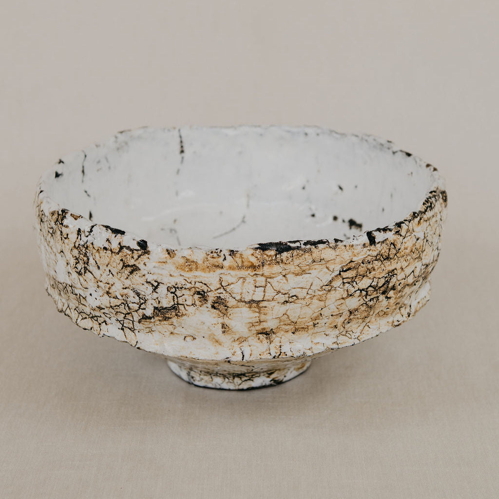 Ceramic bowl with textured surface on a beige background