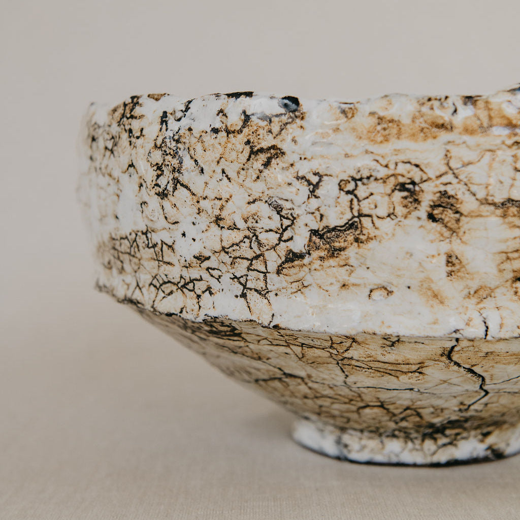 Ceramic bowl with textured surface on a beige background