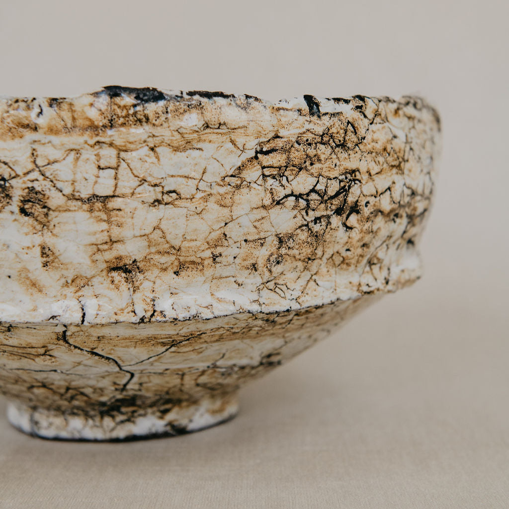 Ceramic bowl with a textured surface on a beige background