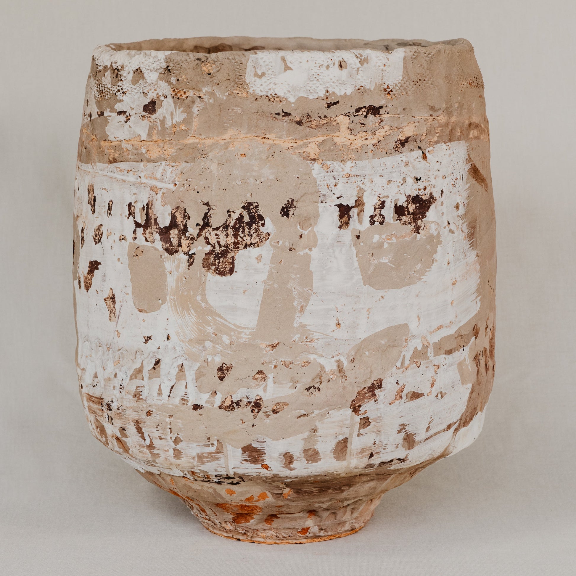 Ceramic pot with textured surface on a plain background