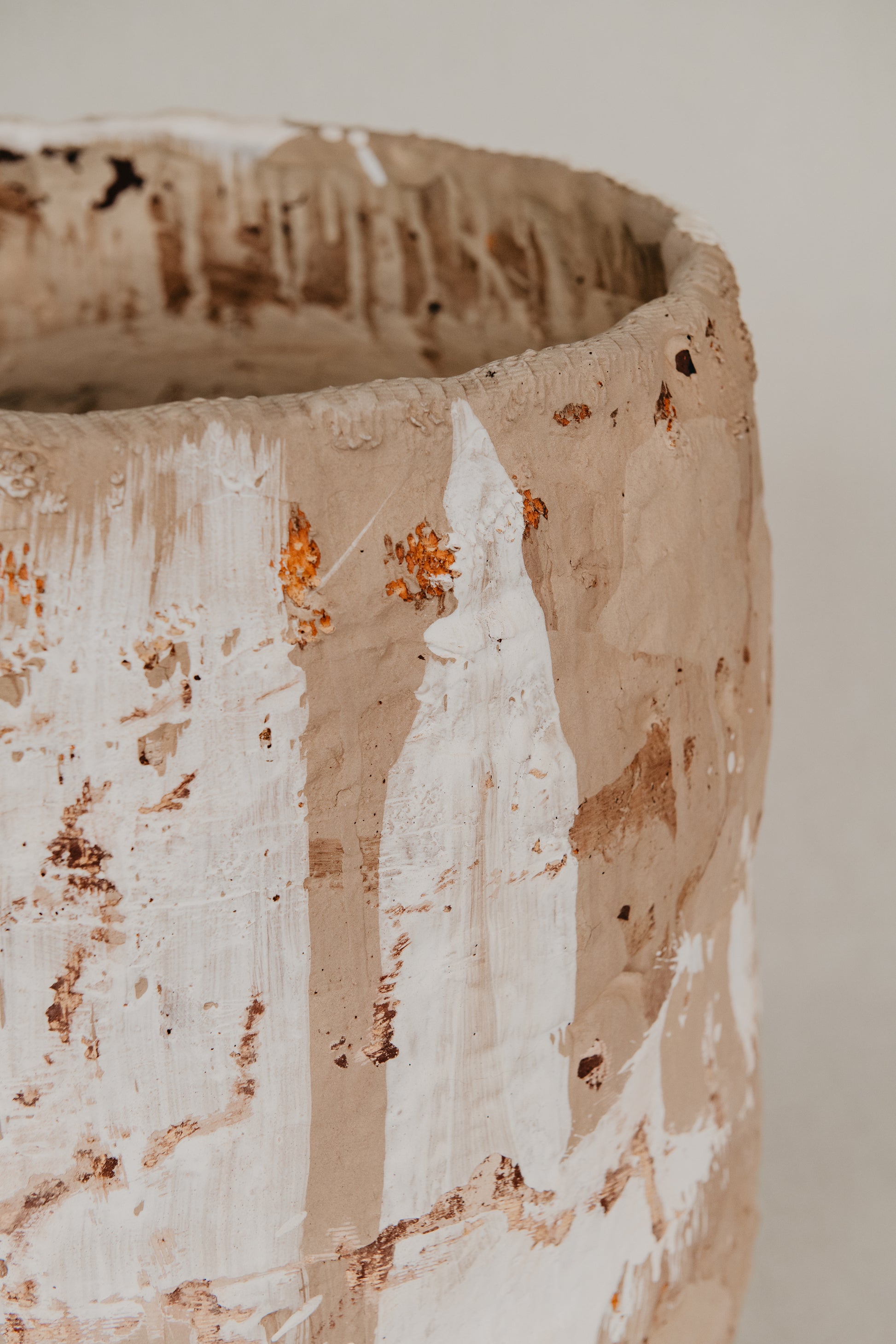 Close-up of a textured ceramic pot with a neutral background