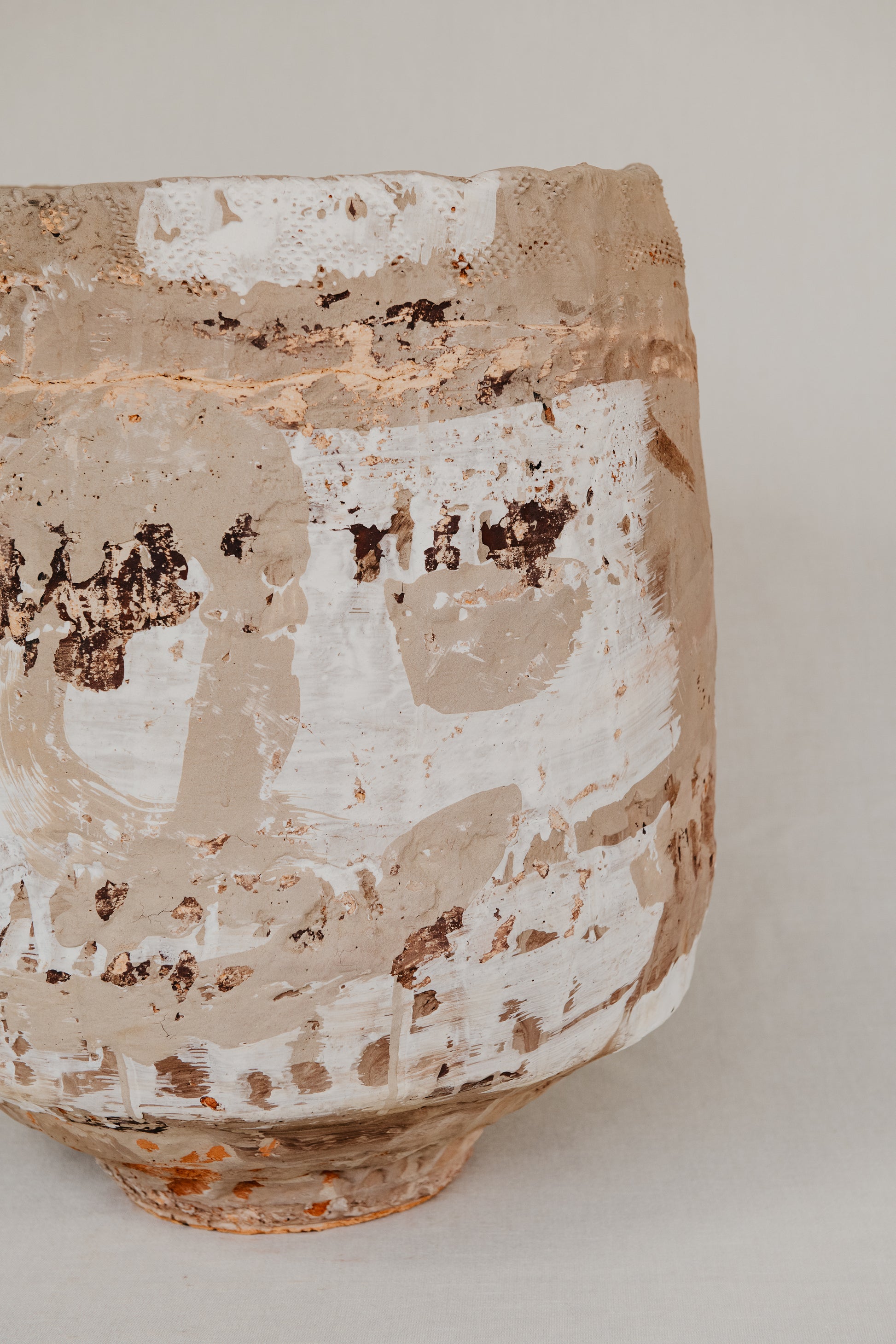 Vintage ceramic vase with textured surface on a plain background