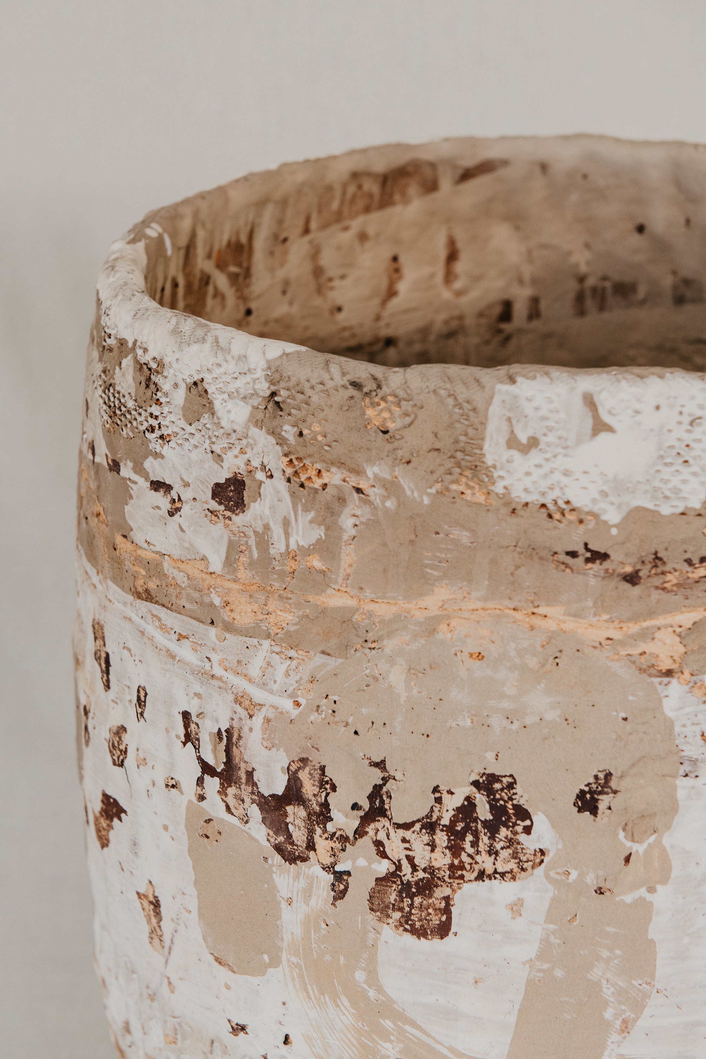 Close-up of a textured ceramic vase with a neutral background