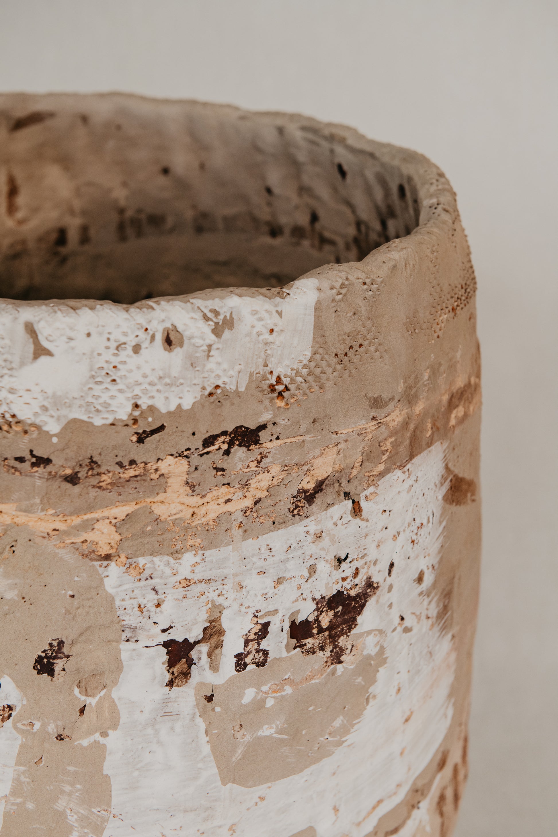 Close-up of a textured ceramic pot with a neutral background
