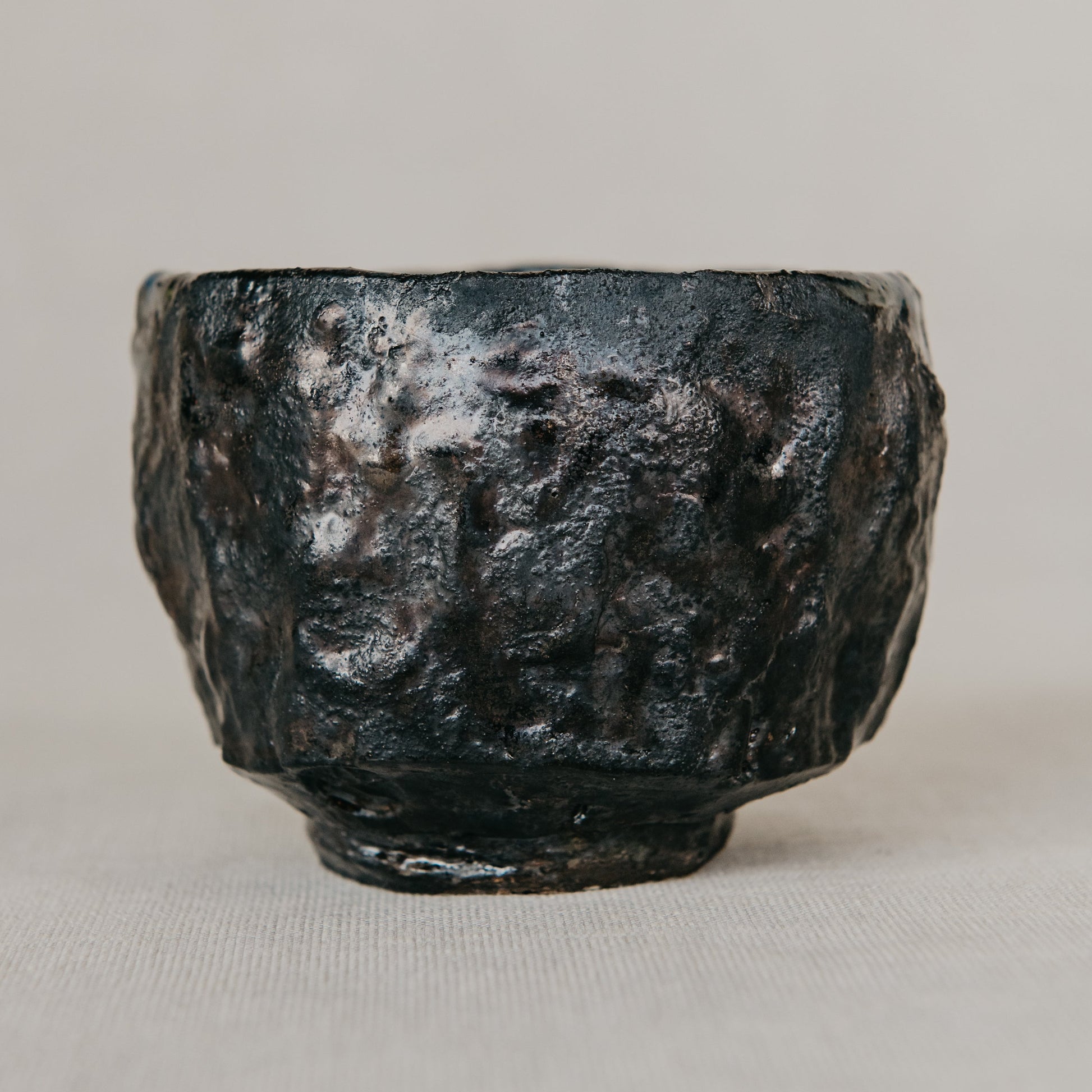 Black stone object on a beige background