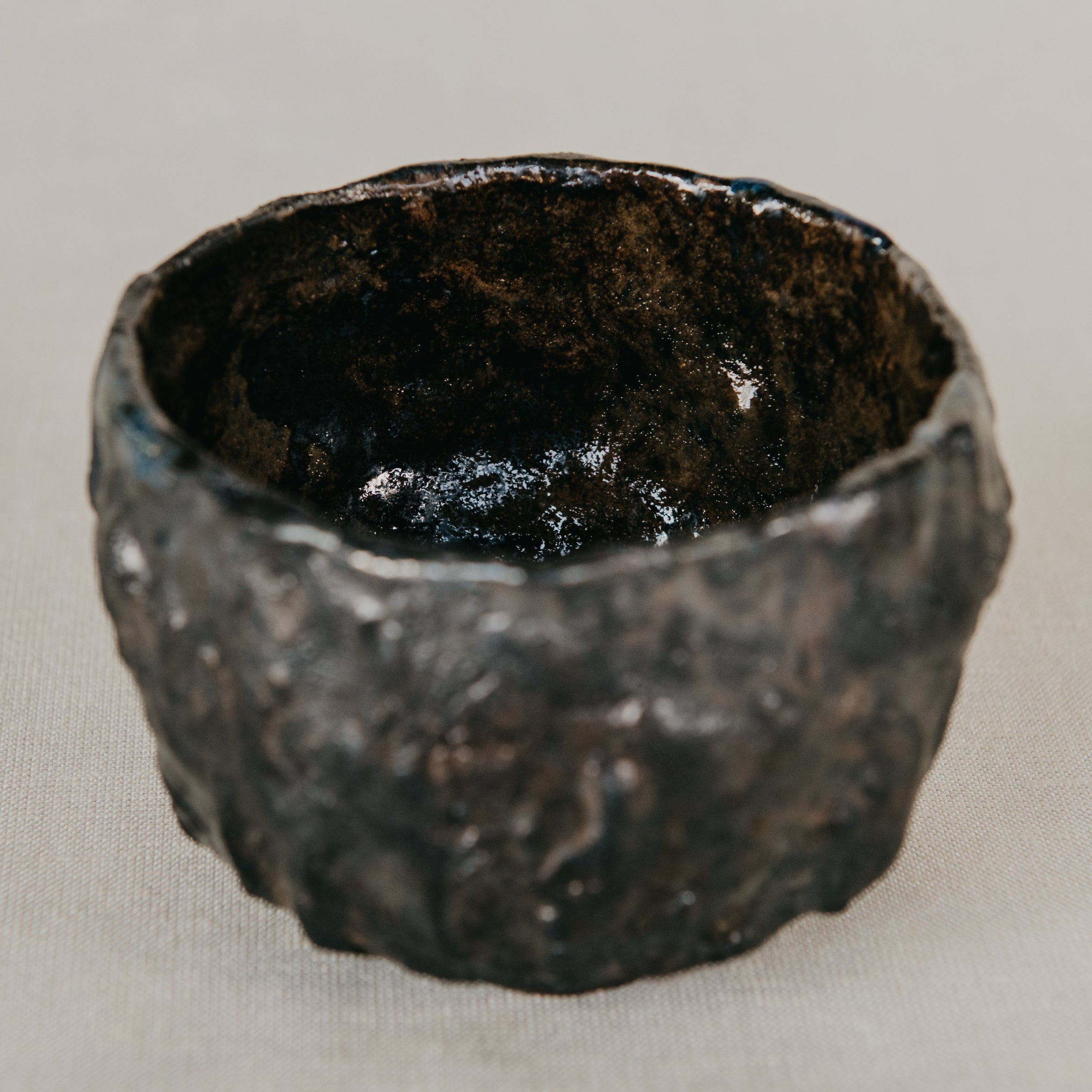 Textured black ceramic bowl on a light gray background