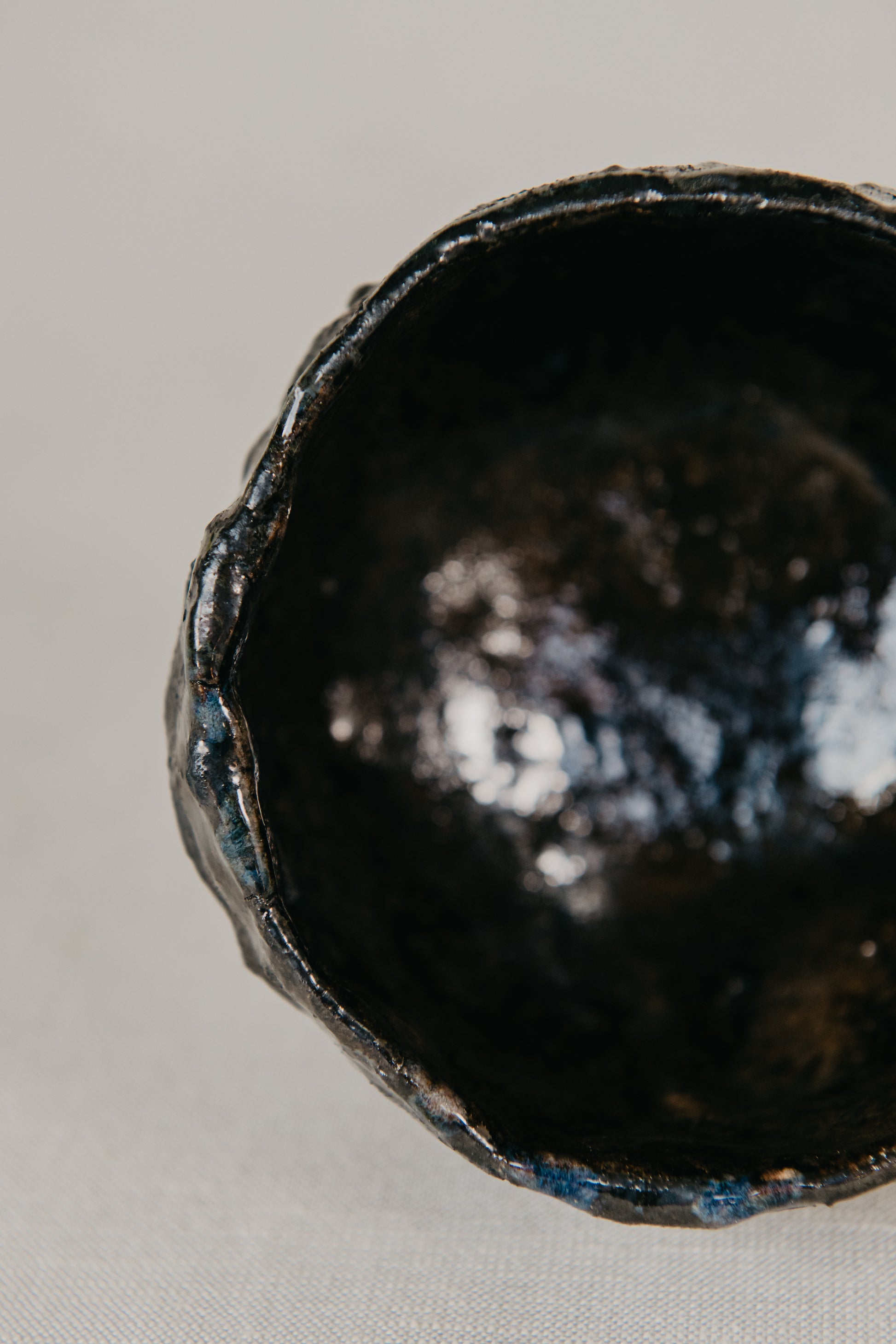 Close-up of a dark ceramic bowl on a light gray background