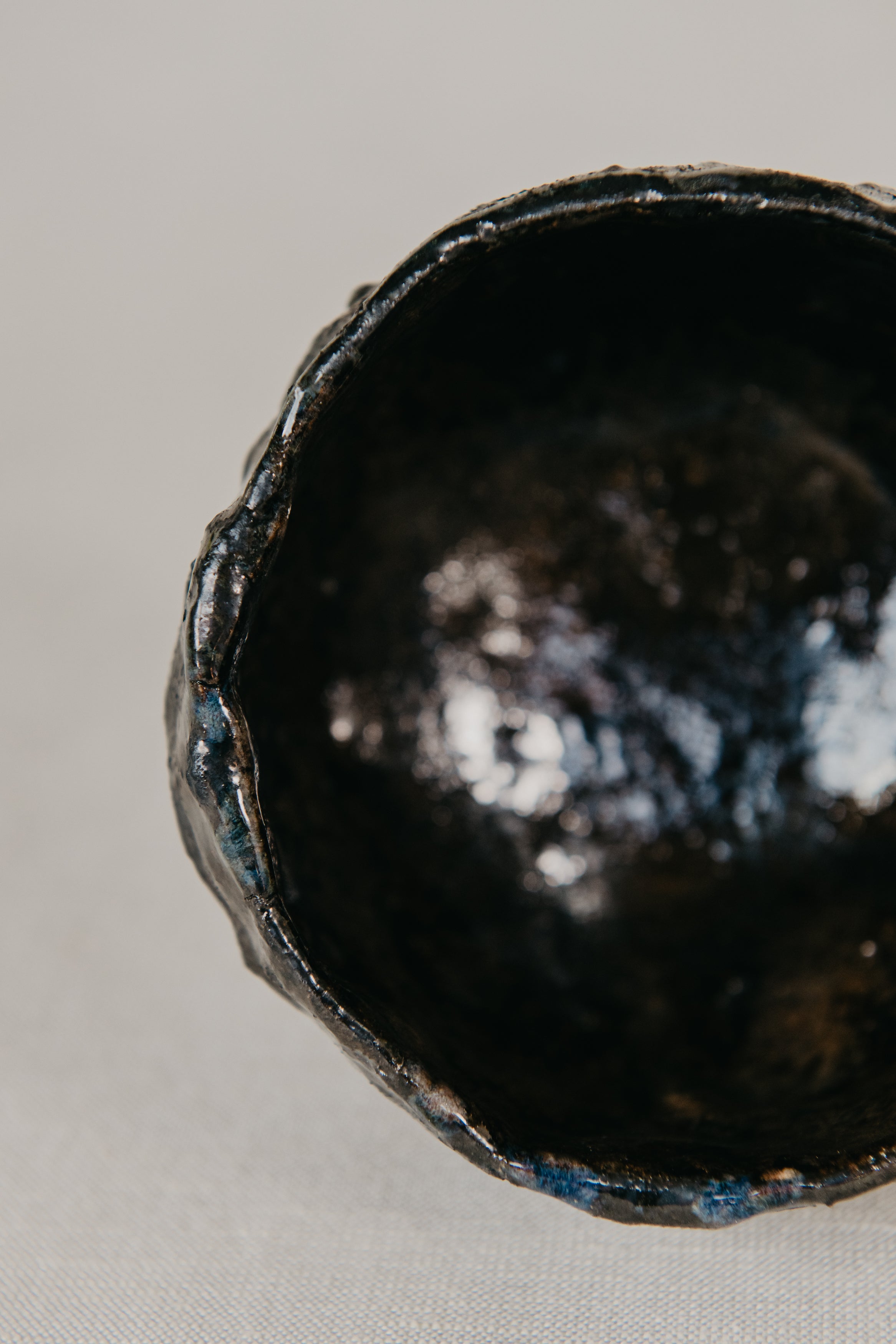 Close-up of a dark ceramic bowl on a light gray background