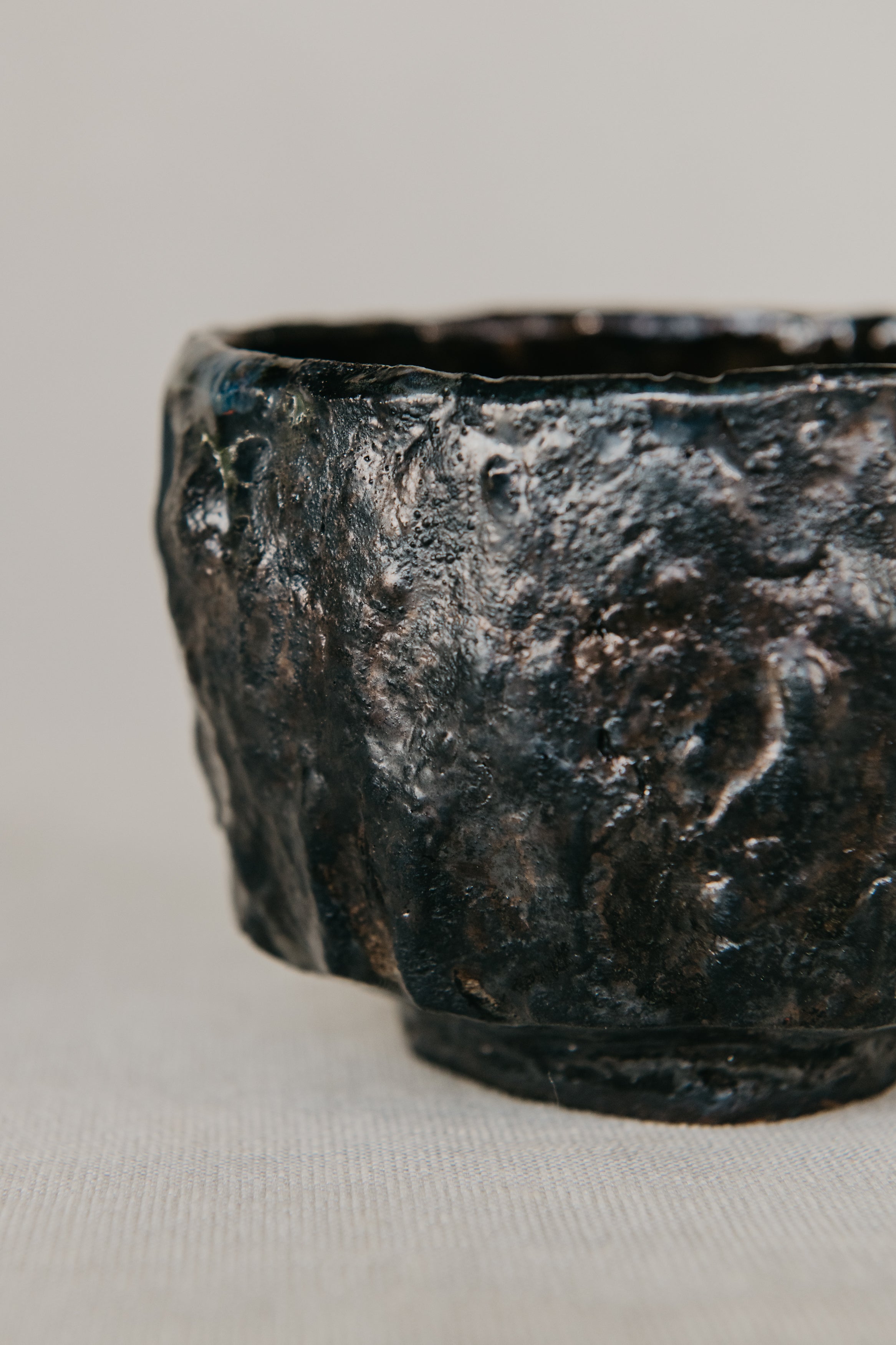 Textured black ceramic bowl on a light gray background