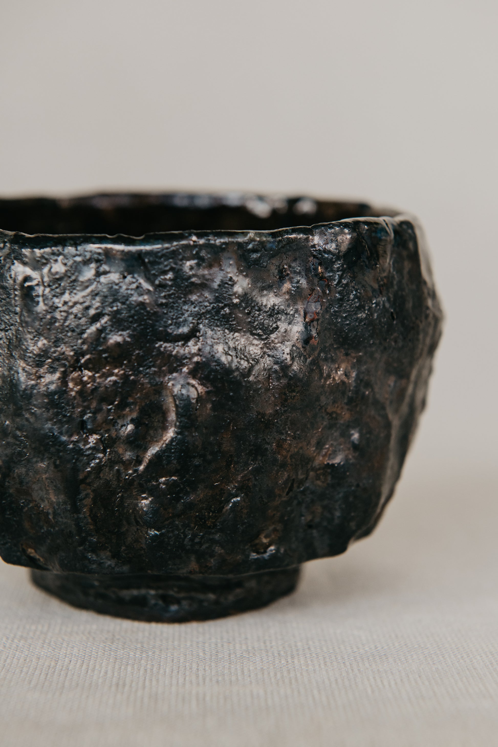 Black ceramic bowl with textured surface on a light gray background