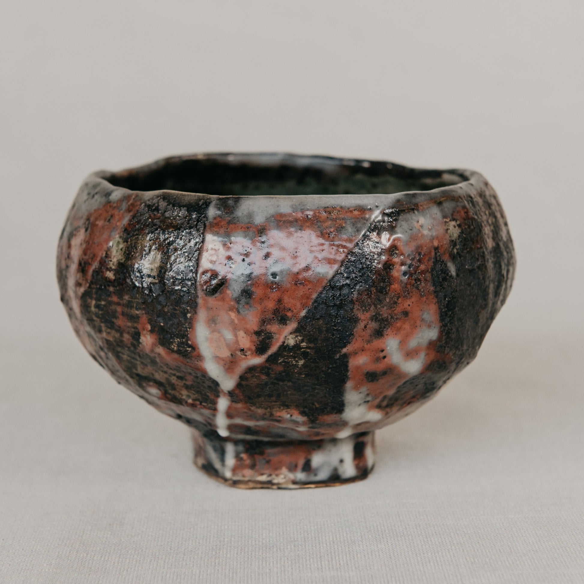 Ceramic bowl with a unique glaze pattern on a plain background