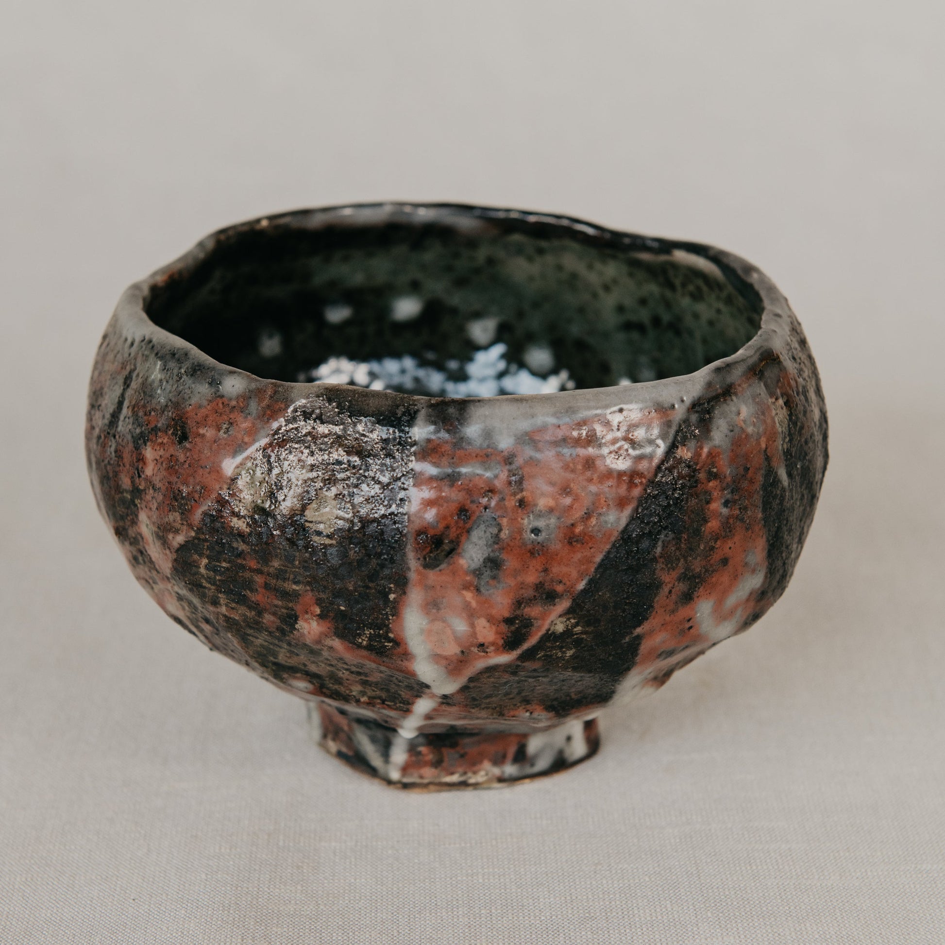 Ceramic bowl with a unique glaze pattern on a neutral background