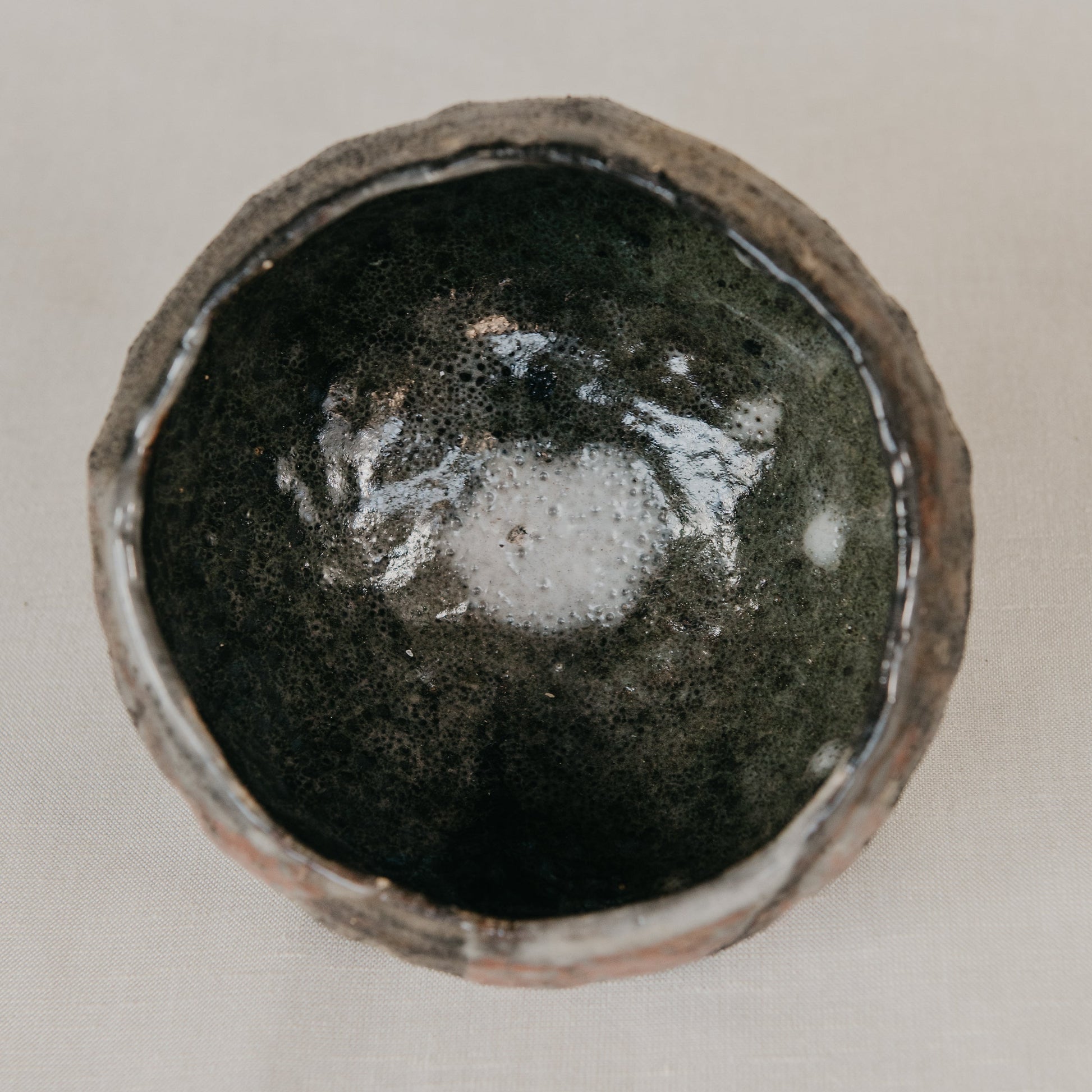 Ceramic bowl with a dark glaze on a light background