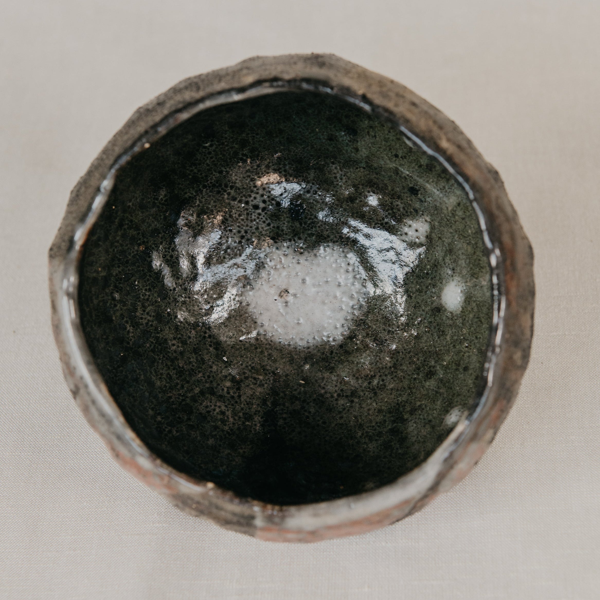 Ceramic bowl with a dark glaze on a light background