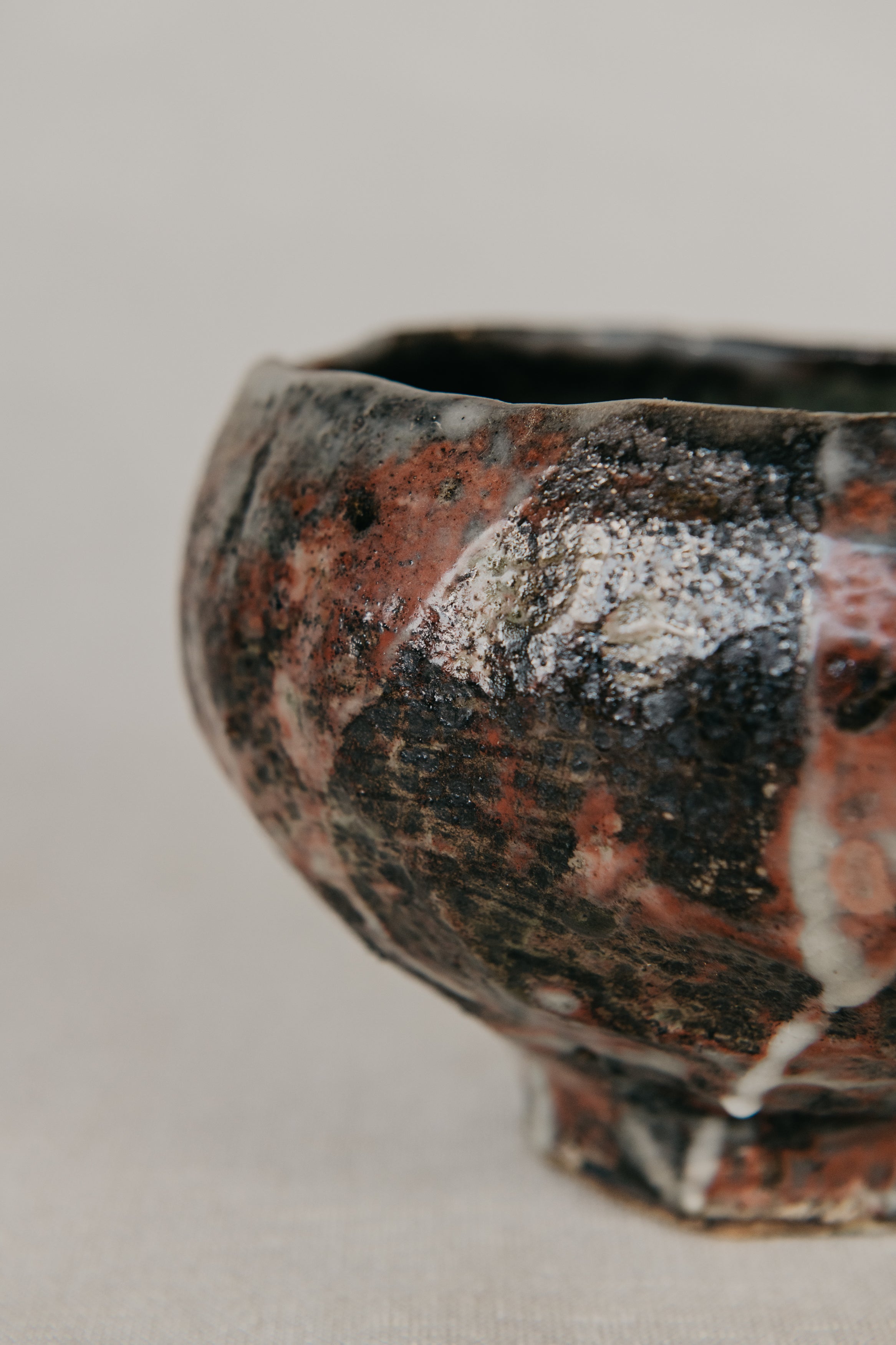 Close-up of a ceramic bowl with a textured surface on a neutral background