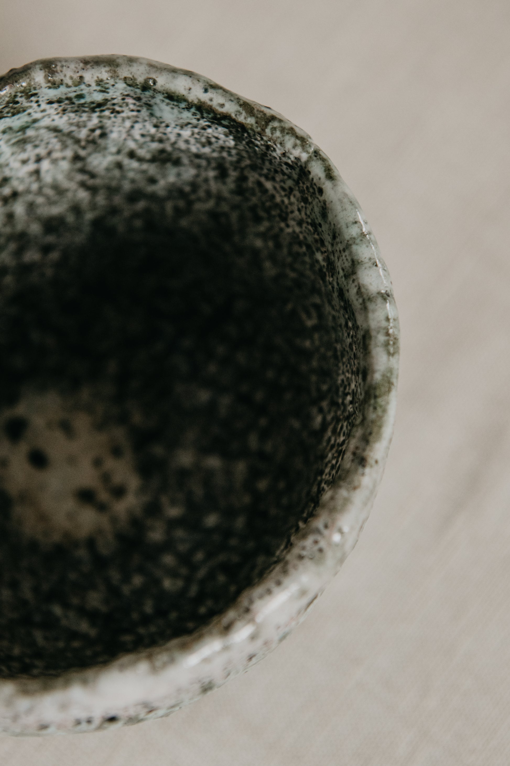 Close-up of a textured ceramic bowl on a neutral background