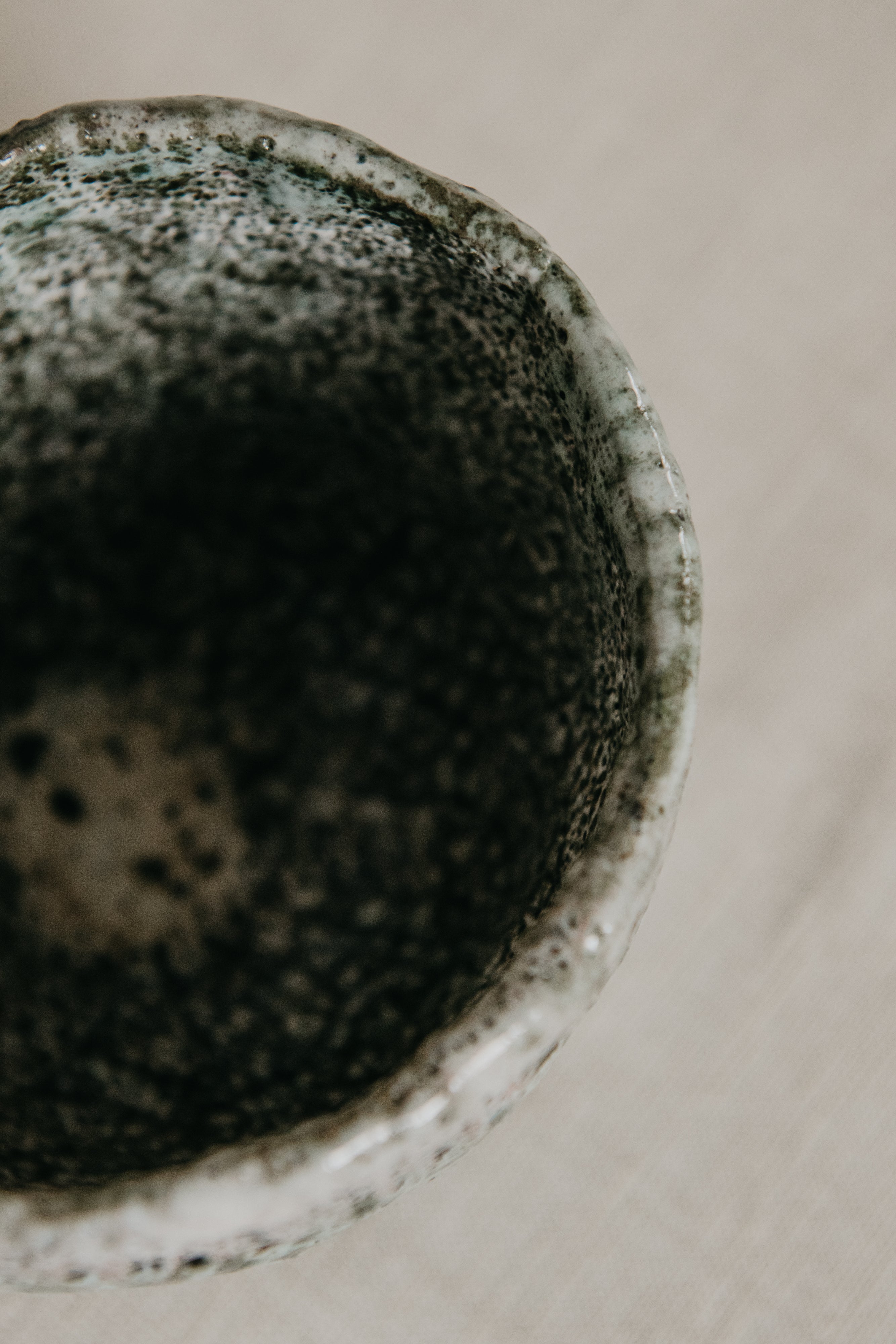 Close-up of a textured ceramic bowl on a neutral background