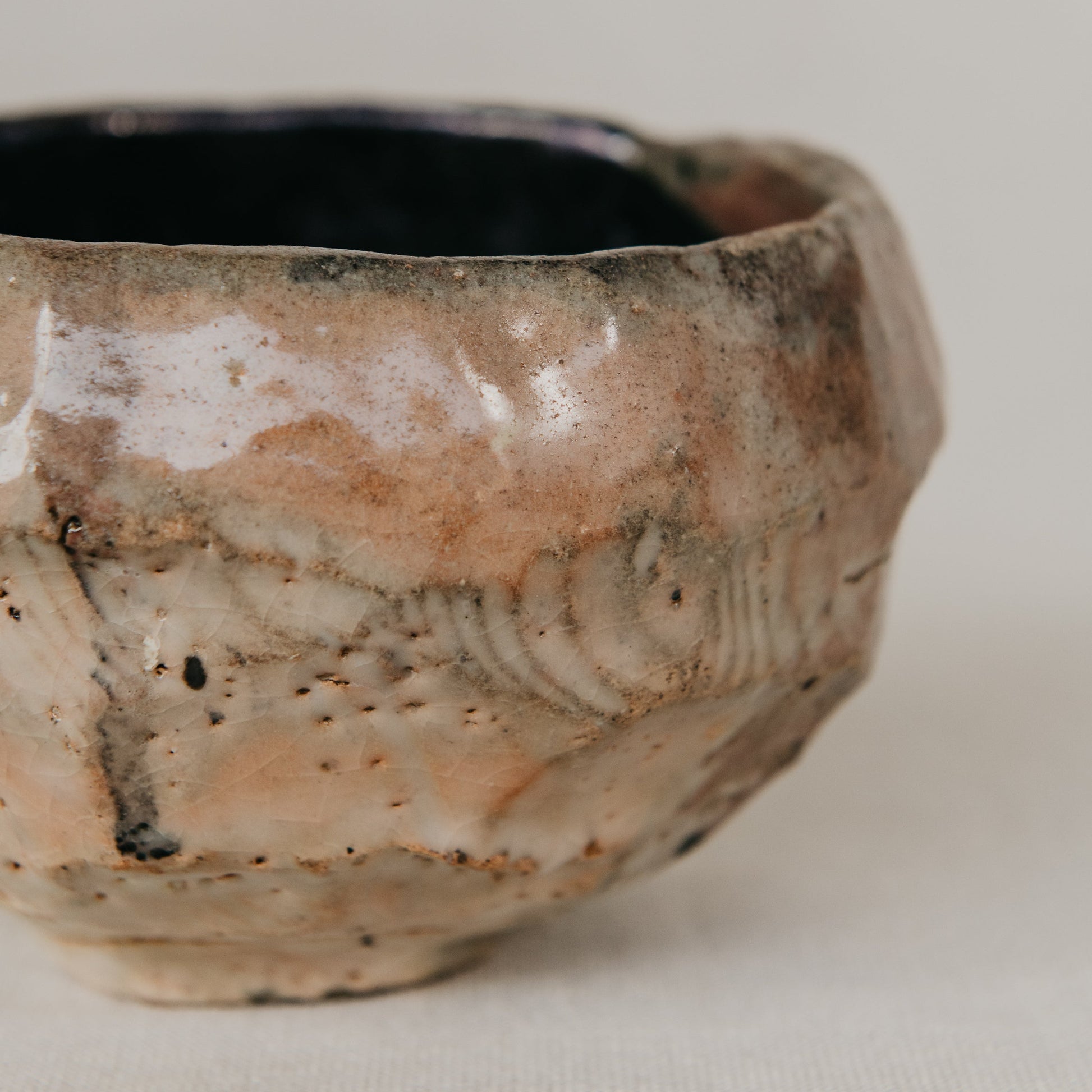 Handmade ceramic bowl with textured surface on a neutral background