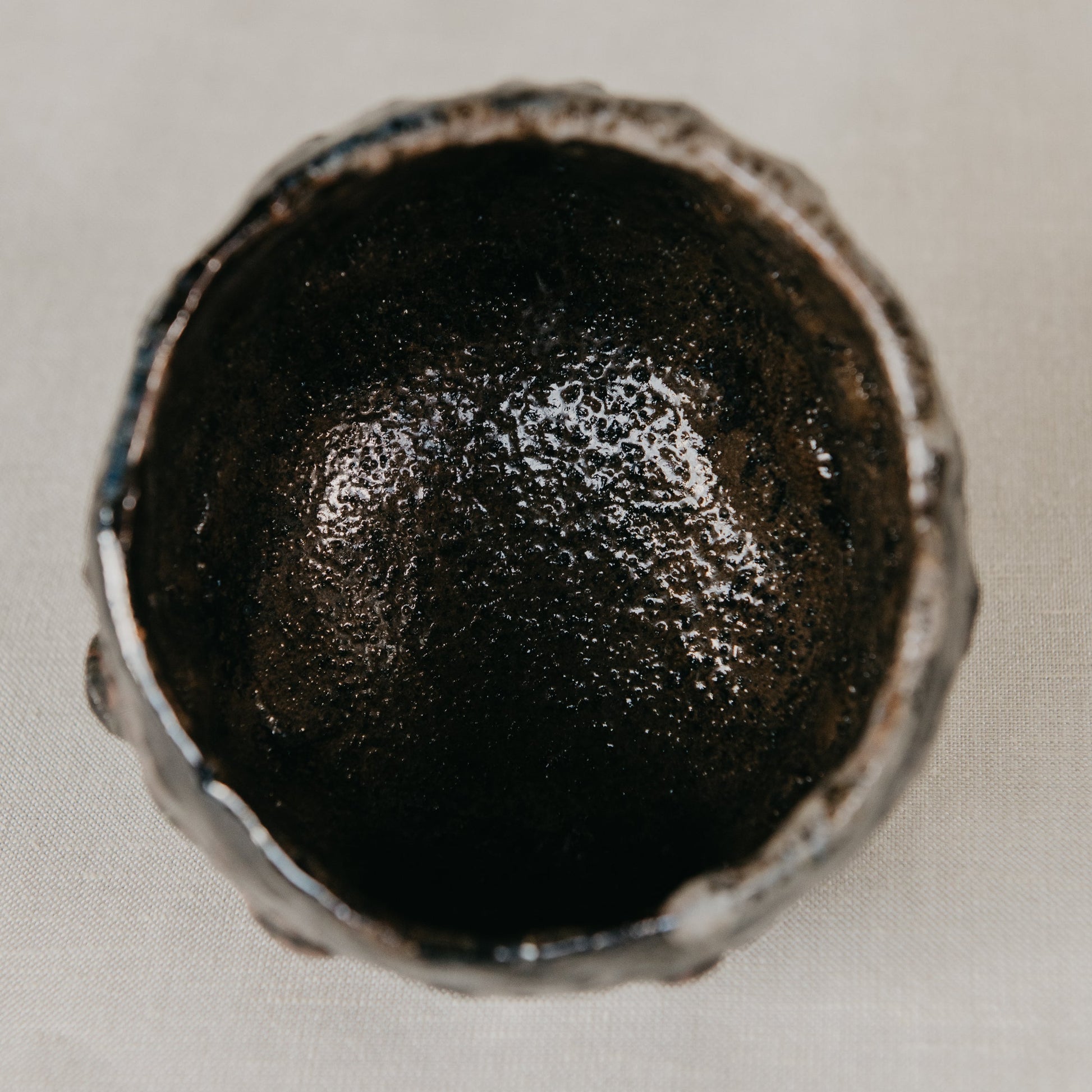 Close-up of a dark metallic object on a light background