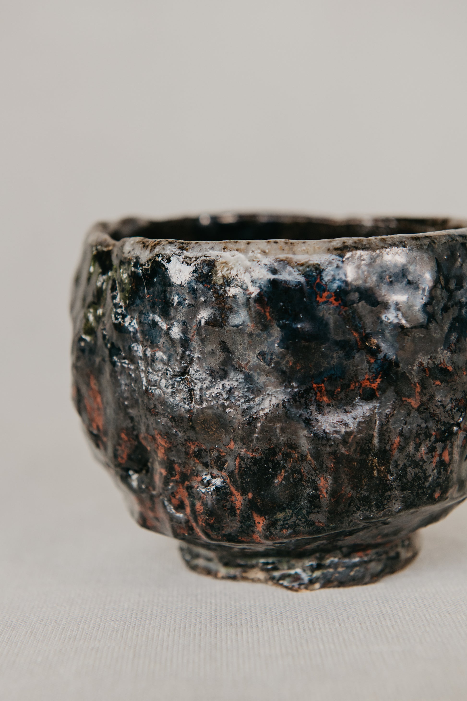 Rustic ceramic bowl with textured surface on a plain background