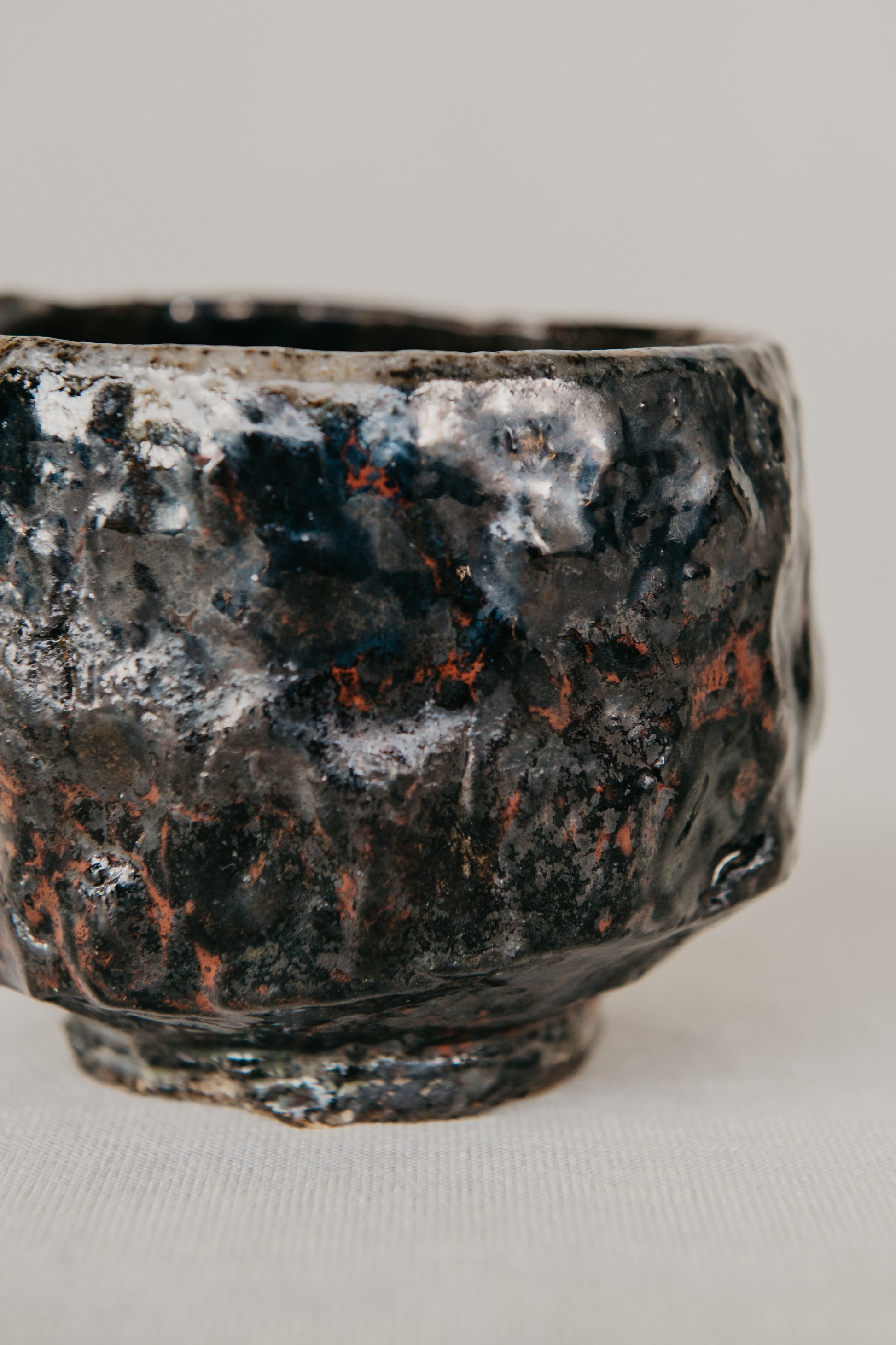 Black ceramic bowl with textured surface on a light background