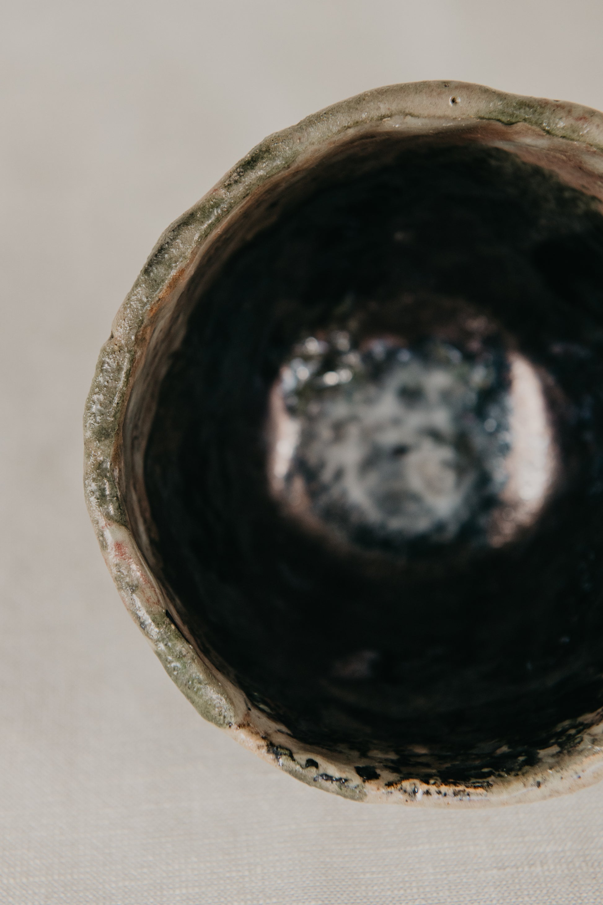 Close-up of a dark ceramic bowl with a circular design on a light background