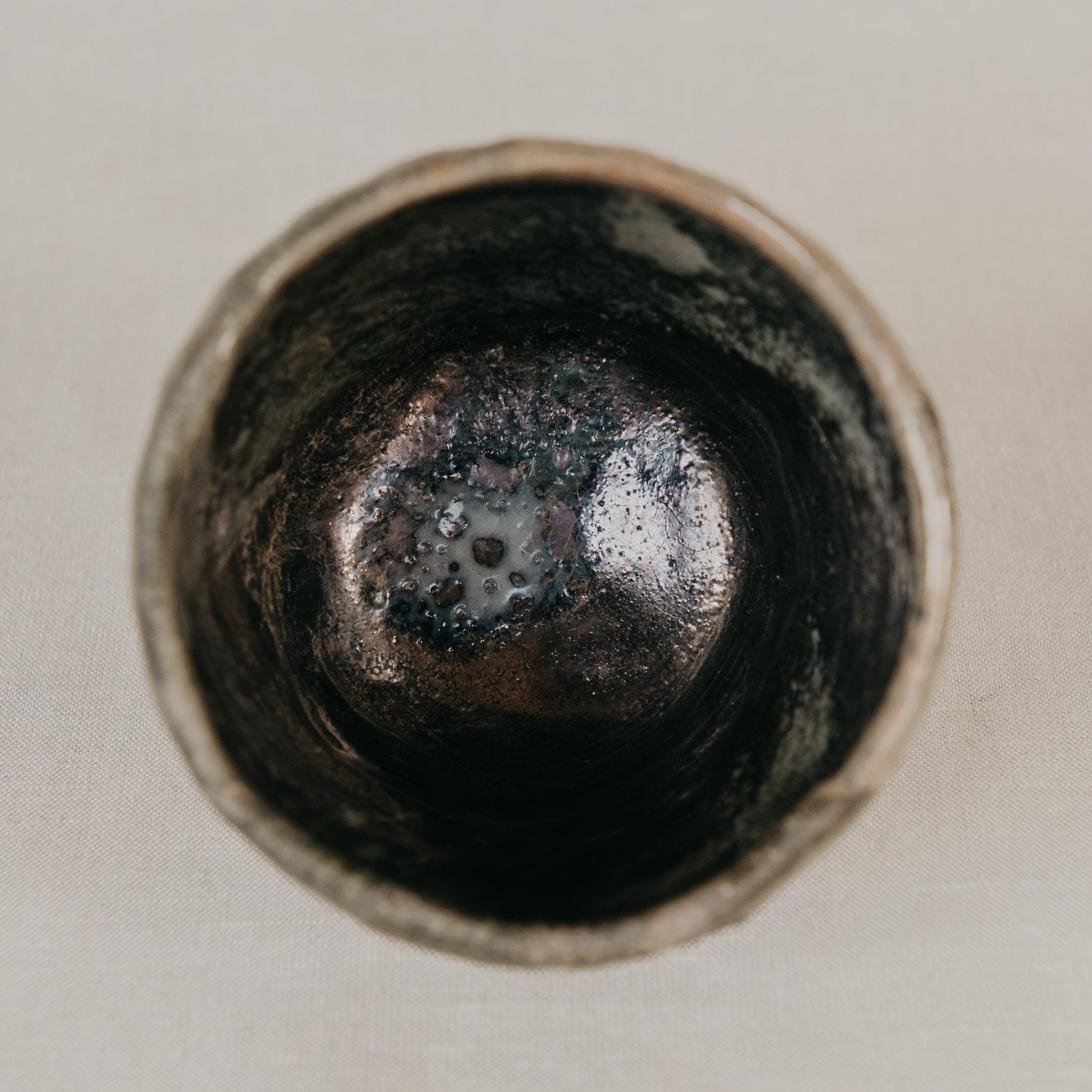 Close-up of a metallic object with a textured surface on a light background