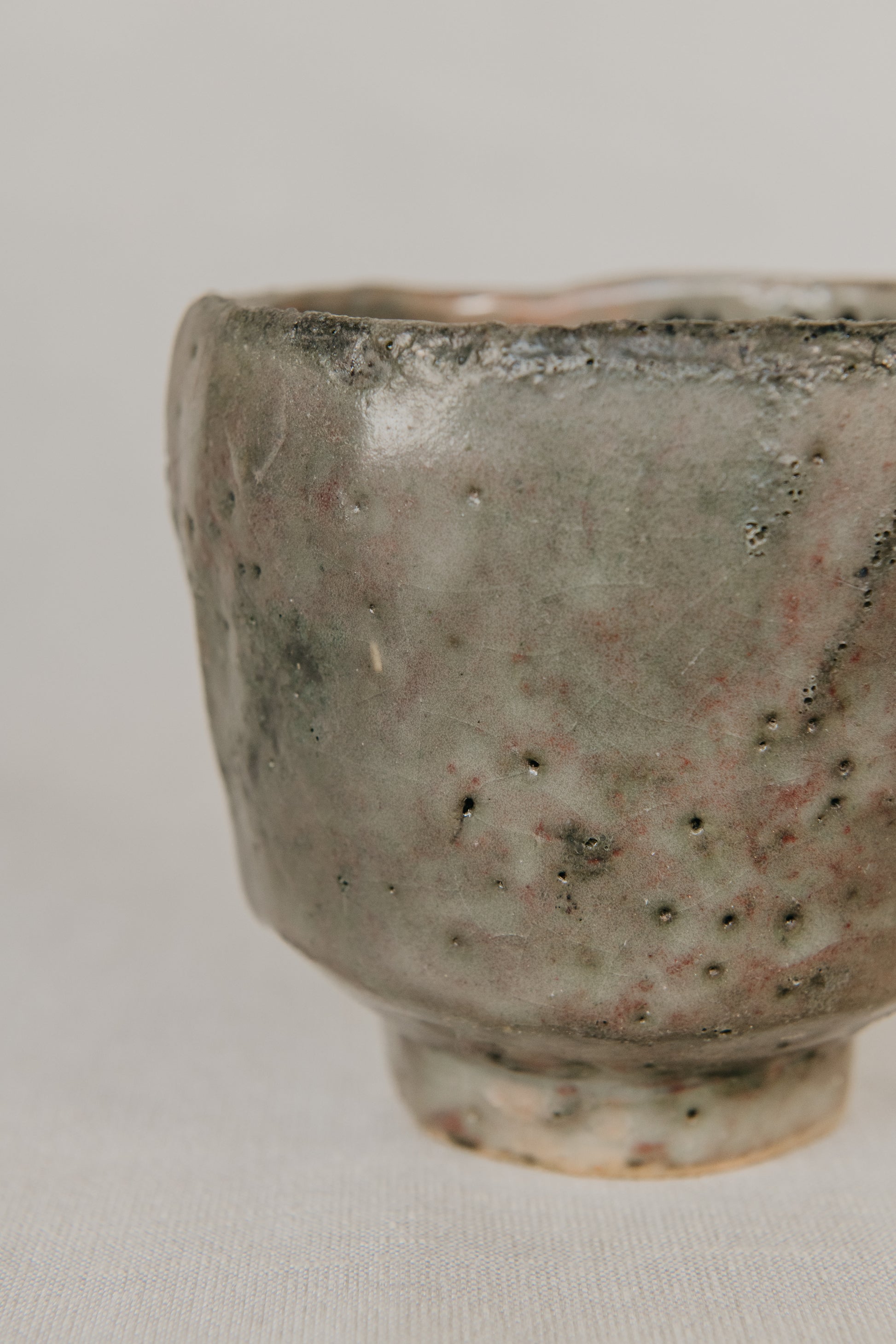 Gray ceramic cup with textured surface on a light gray background