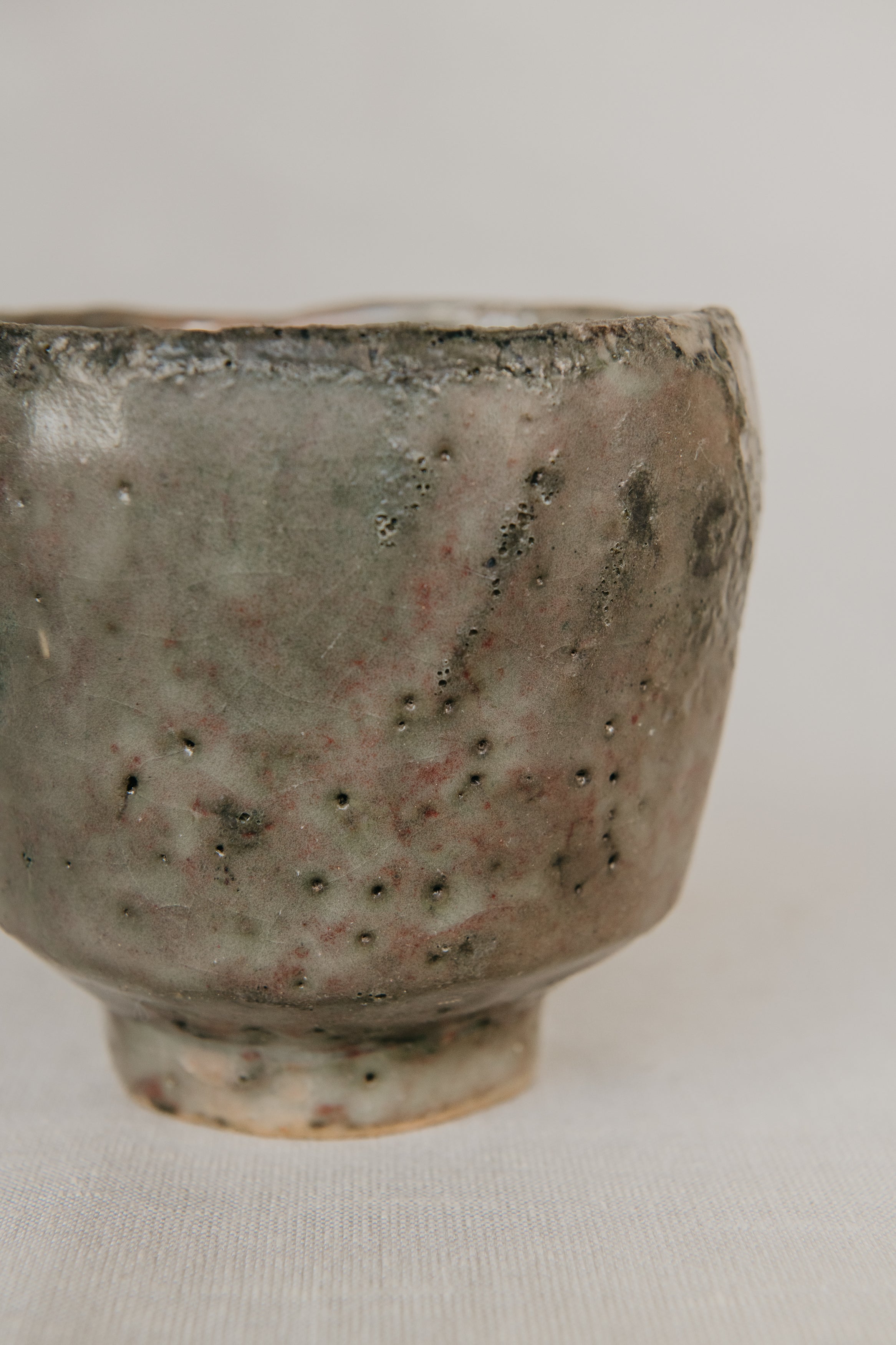 Close-up of a ceramic cup with textured surface on a light background