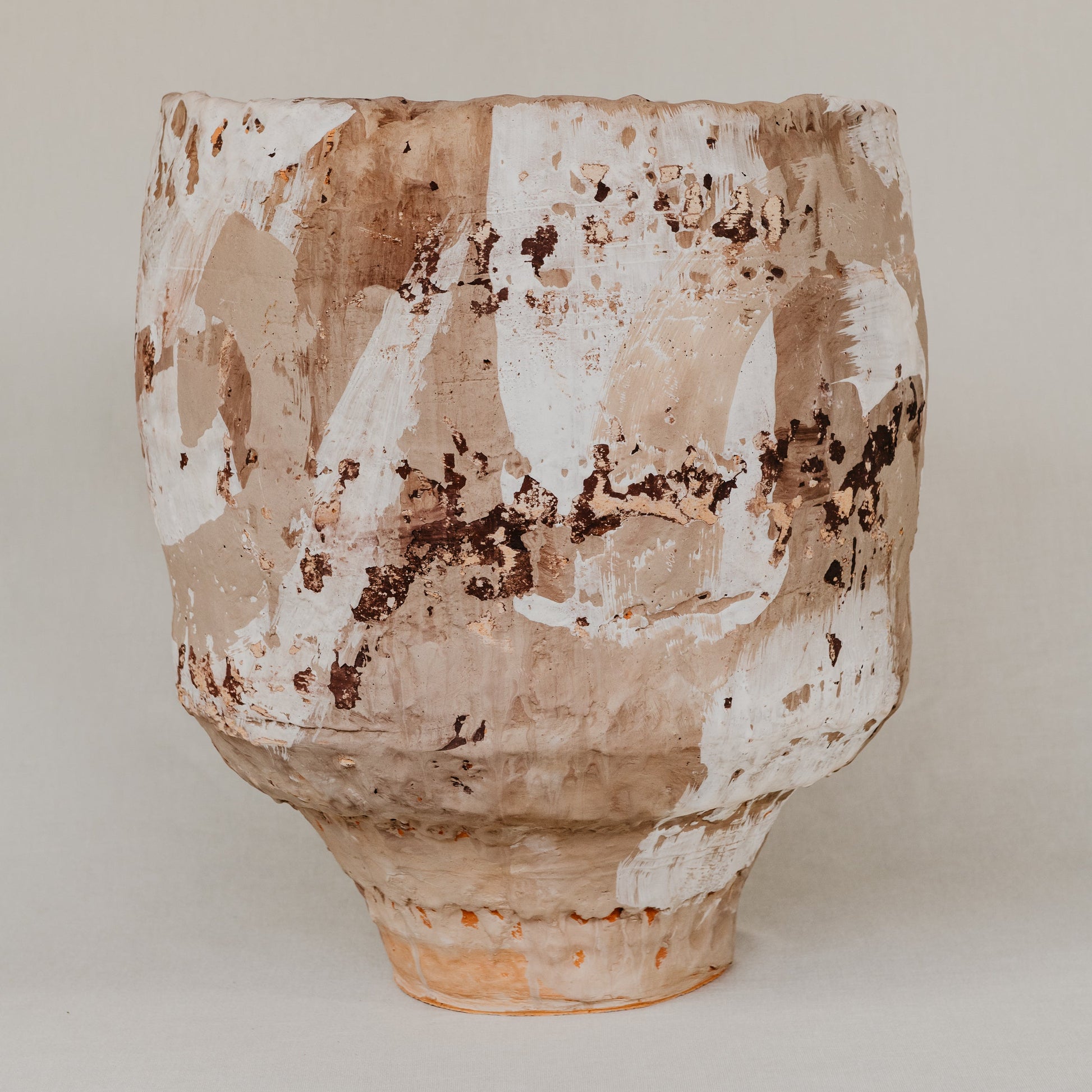 Terracotta pot with a textured surface on a plain background