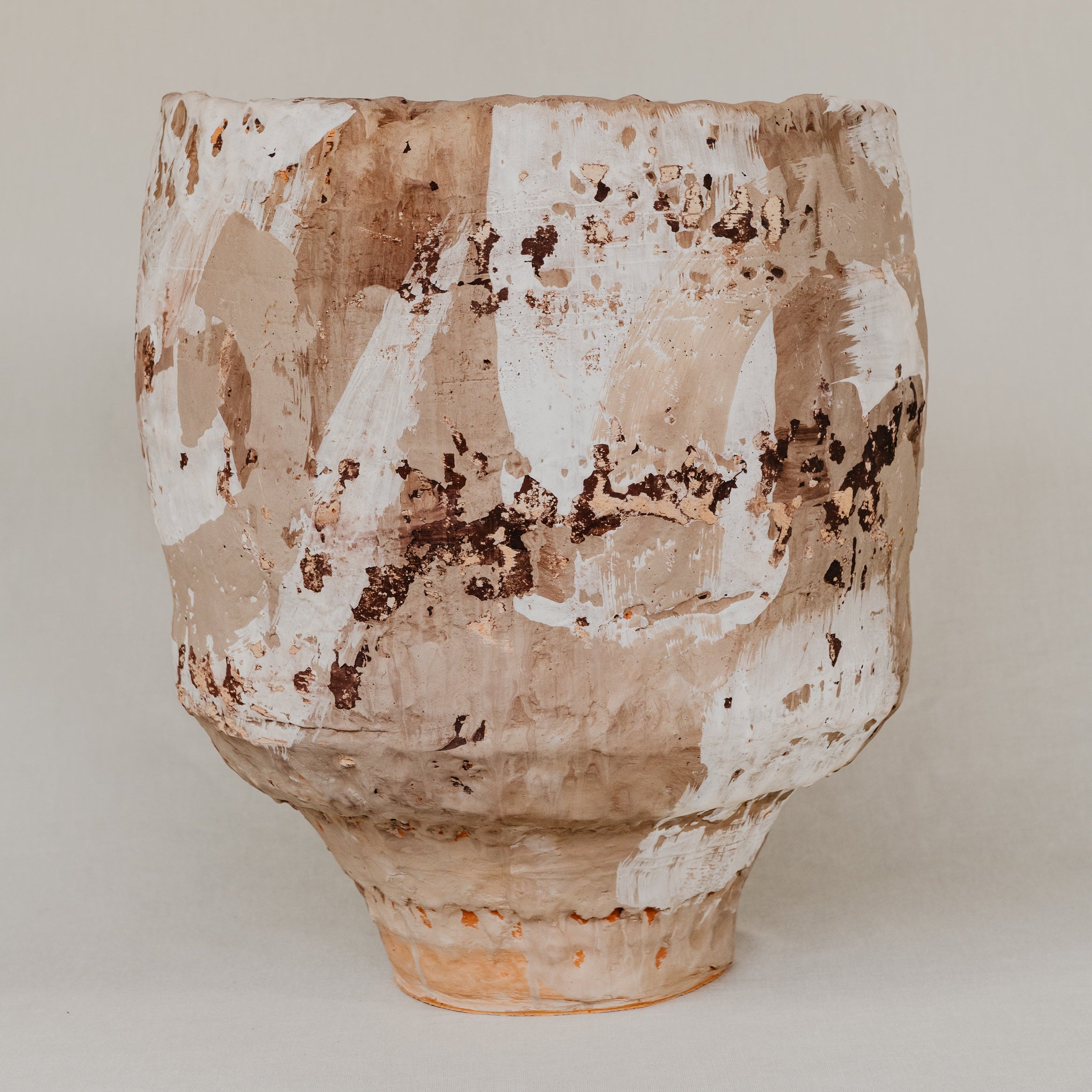Terracotta pot with a textured surface on a plain background