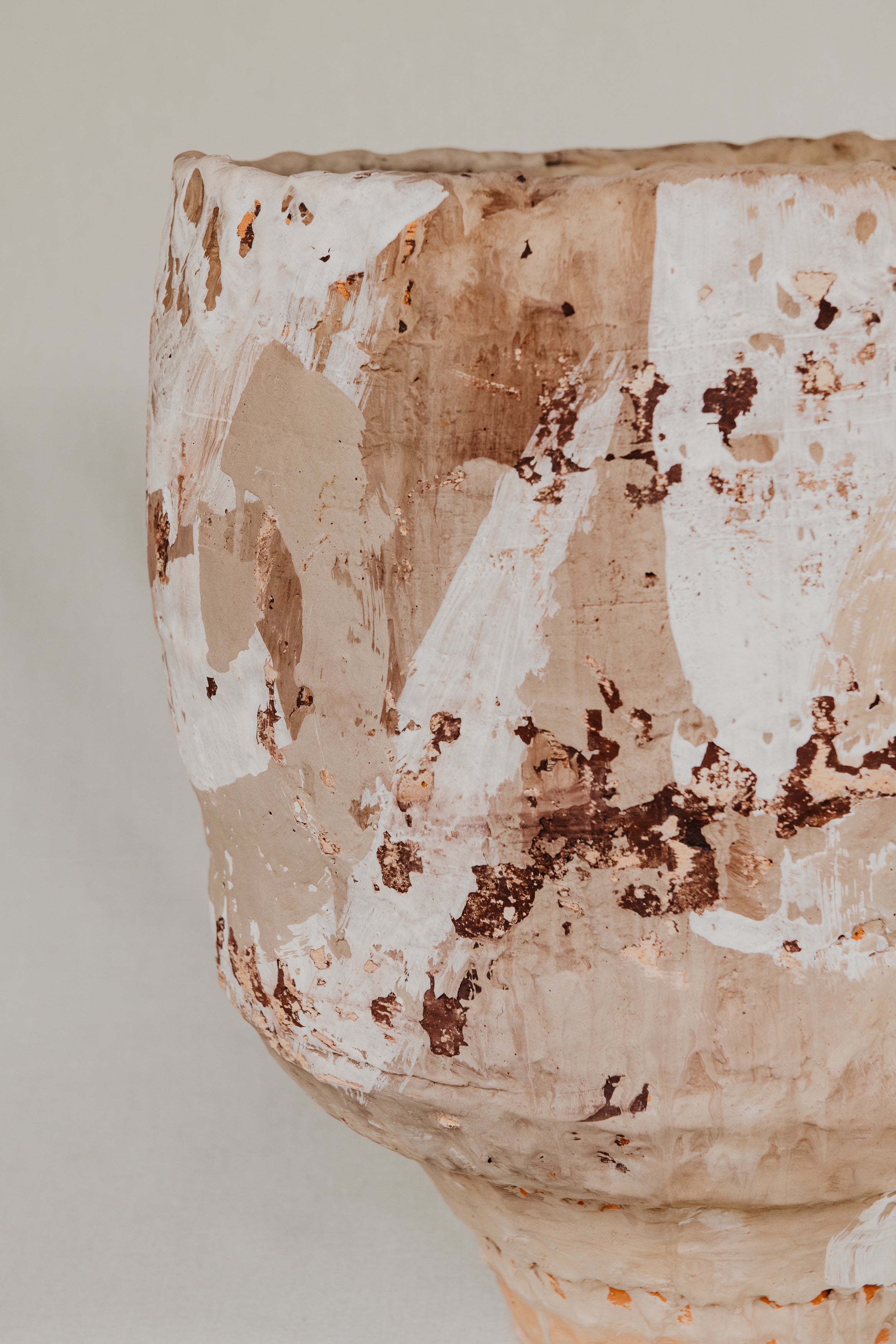 Close-up of a textured ceramic vase with a neutral background